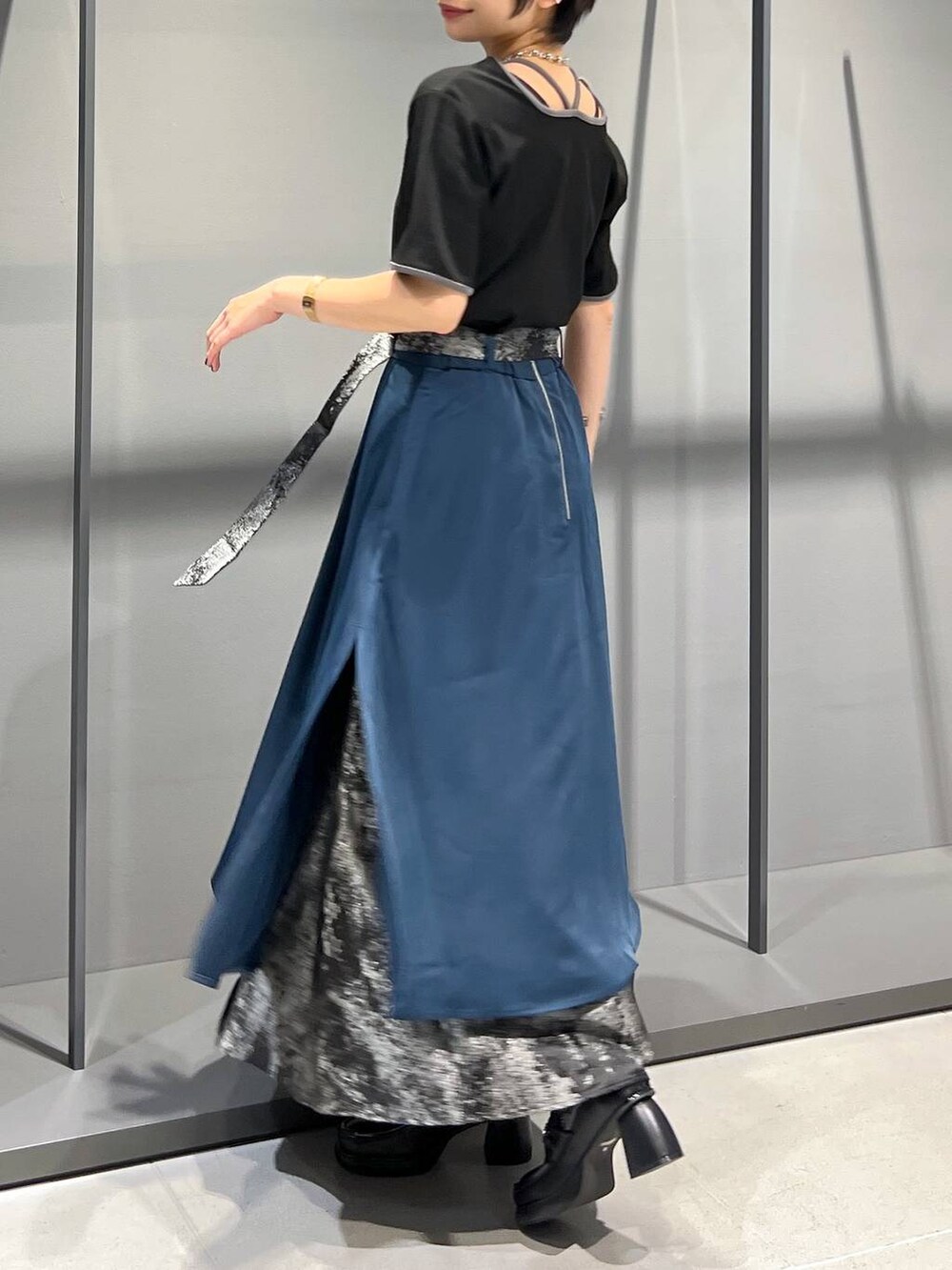 ブラック系のTシャツ/カットソー、ブラック系のローファー、ブルー系のスカートを着用したレディースの夏コーディネートの4枚目の写真