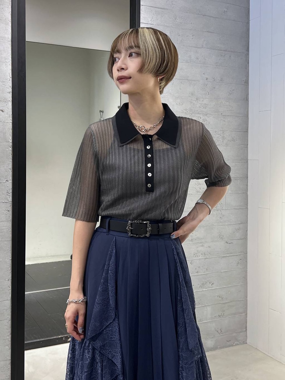 ブラック系のサンダル、ブラック系のポロシャツ、ブルー系のスカートを着用したレディースの夏コーディネートの2枚目の写真