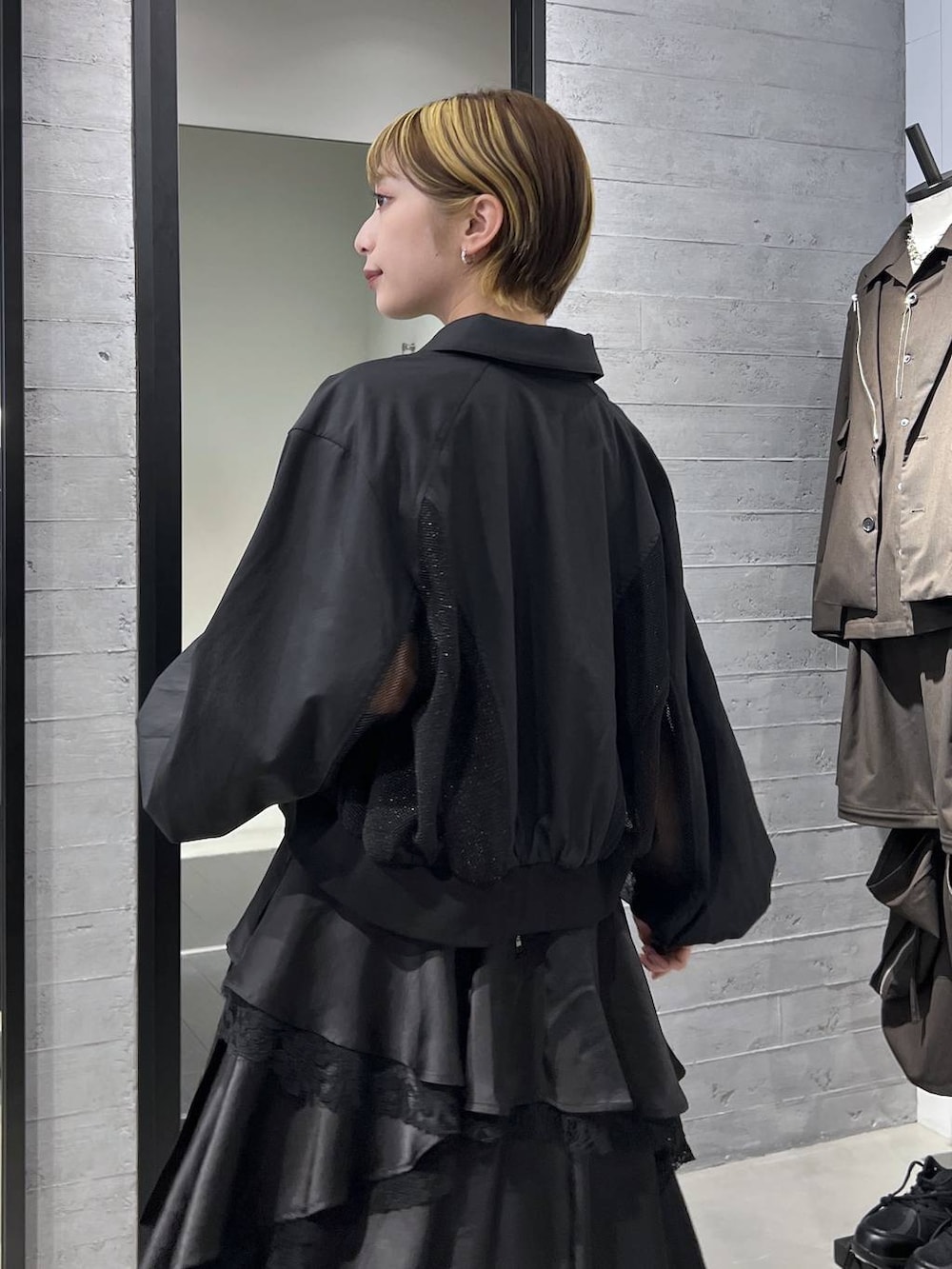 ブラック系のブーツ、ブラック系のスカート、ブラック系のブルゾンを着用したレディースの春コーディネートの3枚目の写真