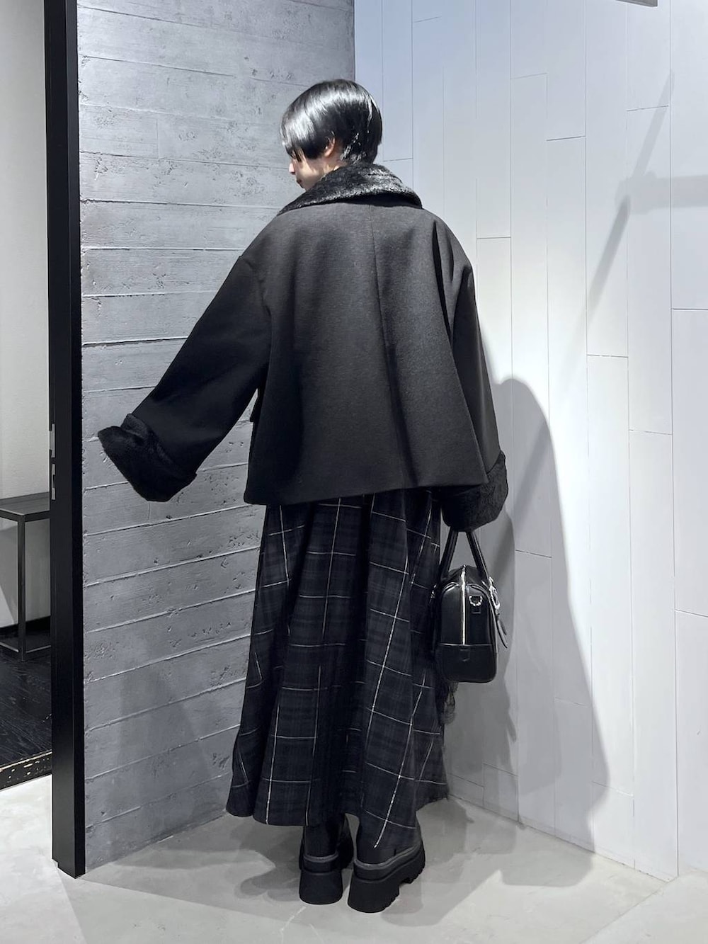 ブラック系のピーコート、ブラック系のニット/セーター、ブラック系のボストンバッグを着用したレディースの秋コーディネートの7枚目の写真