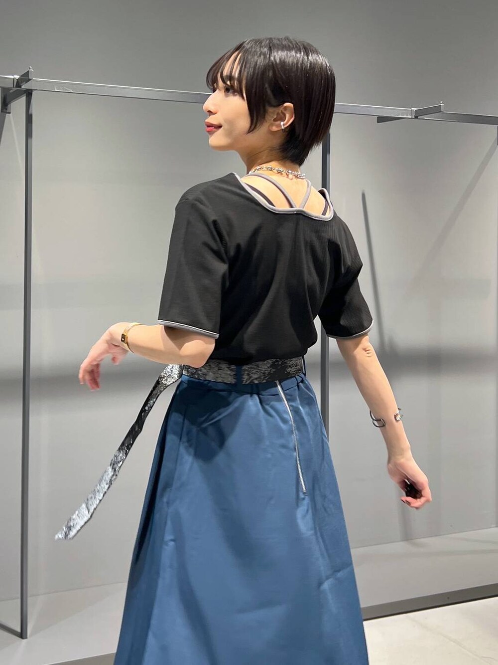 ブラック系のTシャツ/カットソー、ブラック系のローファー、ブルー系のスカートを着用したレディースの夏コーディネートの3枚目の写真