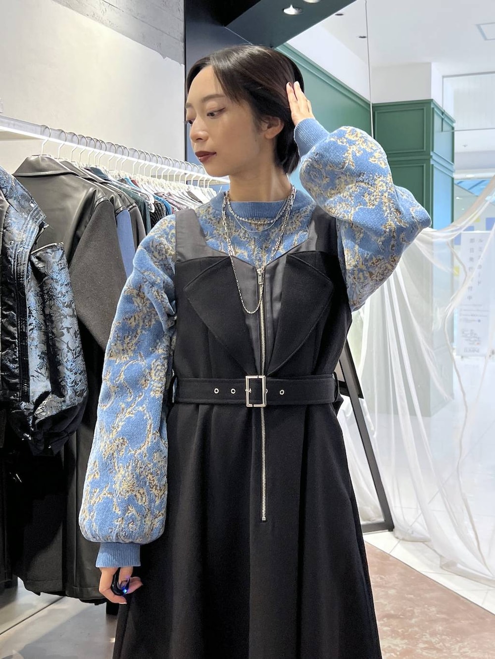 ブルー系のニット/セーター、ブラック系のブーツ、ブラック系のワンピースを着用したレディースの秋コーディネートの2枚目の写真