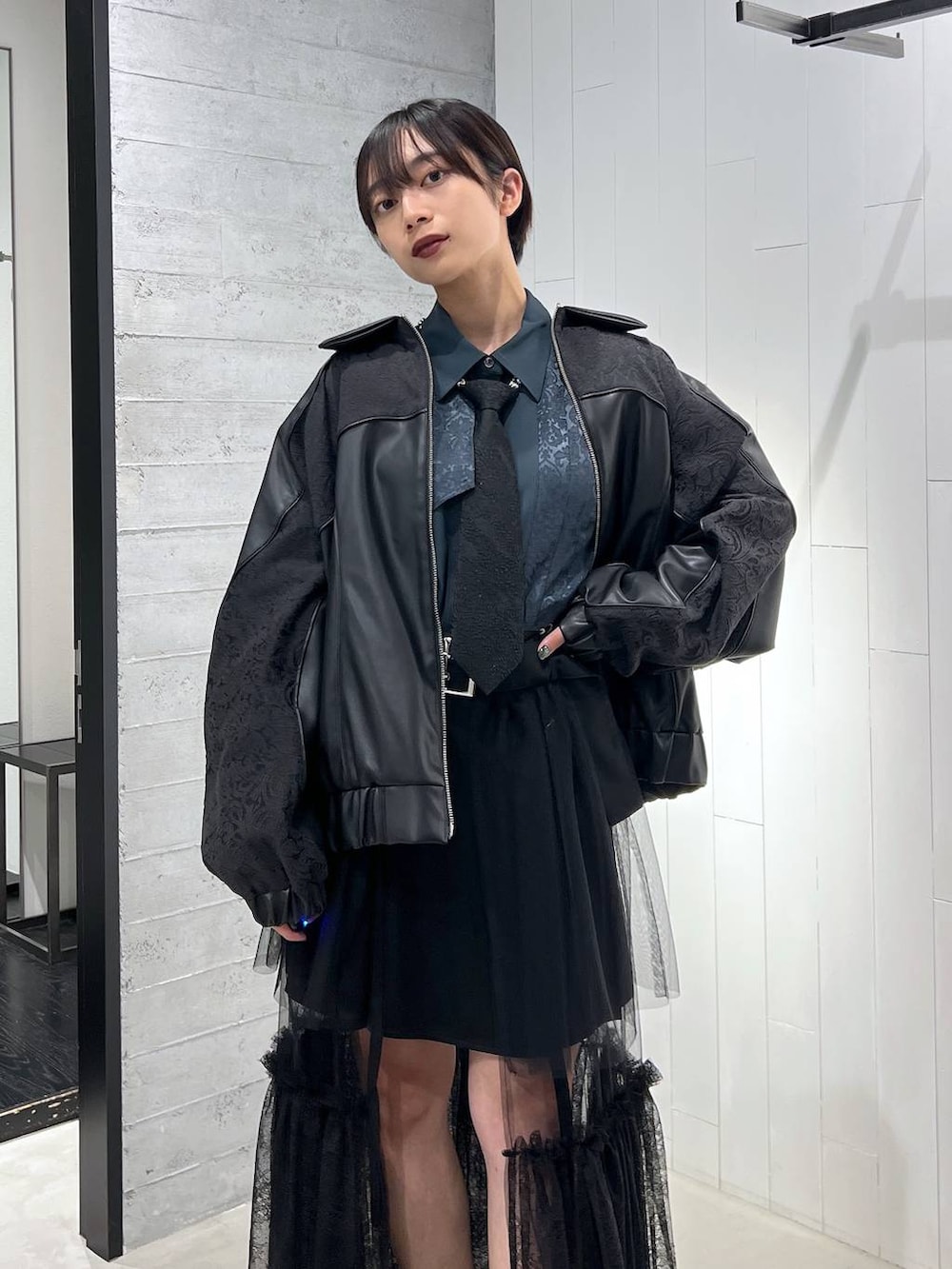 ブラック系のネクタイ、ブラック系のブルゾン、ブラック系のその他パンツを着用したレディースの秋コーディネートの2枚目の写真