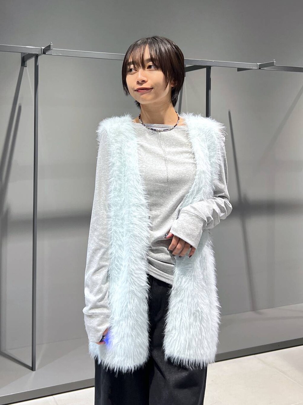 グリーン系のカーディガン/ボレロ、グレー系のTシャツ/カットソー、ブラック系のブーツを着用したレディースの秋コーディネートの2枚目の写真