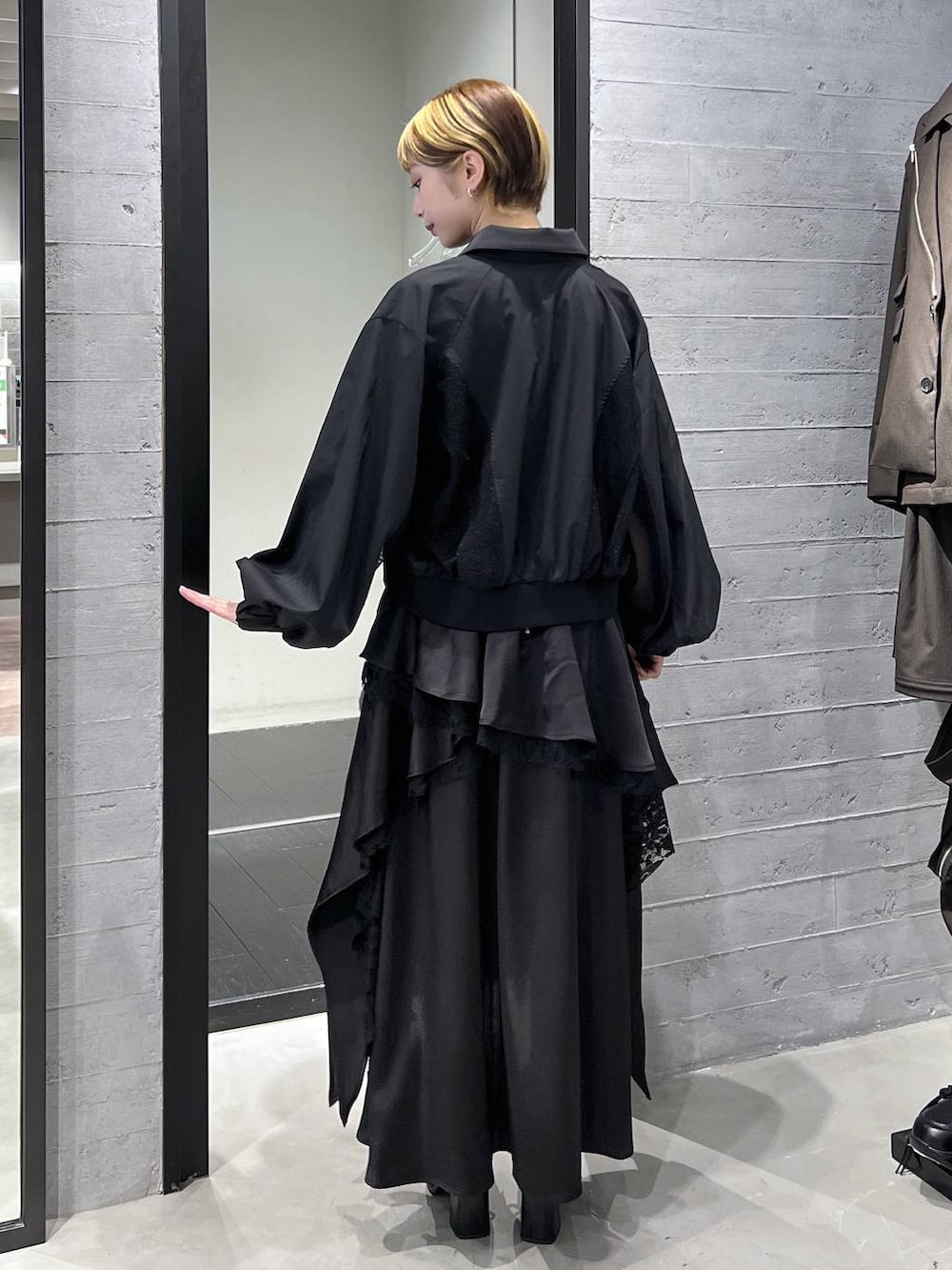 ブラック系のブーツ、ブラック系のスカート、ブラック系のブルゾンを着用したレディースの春コーディネートの7枚目の写真