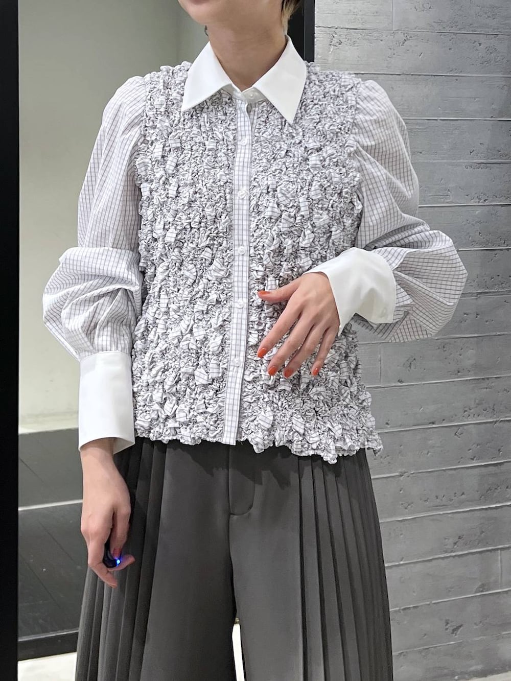 ブラック系のブーツ、ホワイト系のシャツ/ブラウス、グレー系のスラックスを着用したレディースの冬コーディネートの2枚目の写真