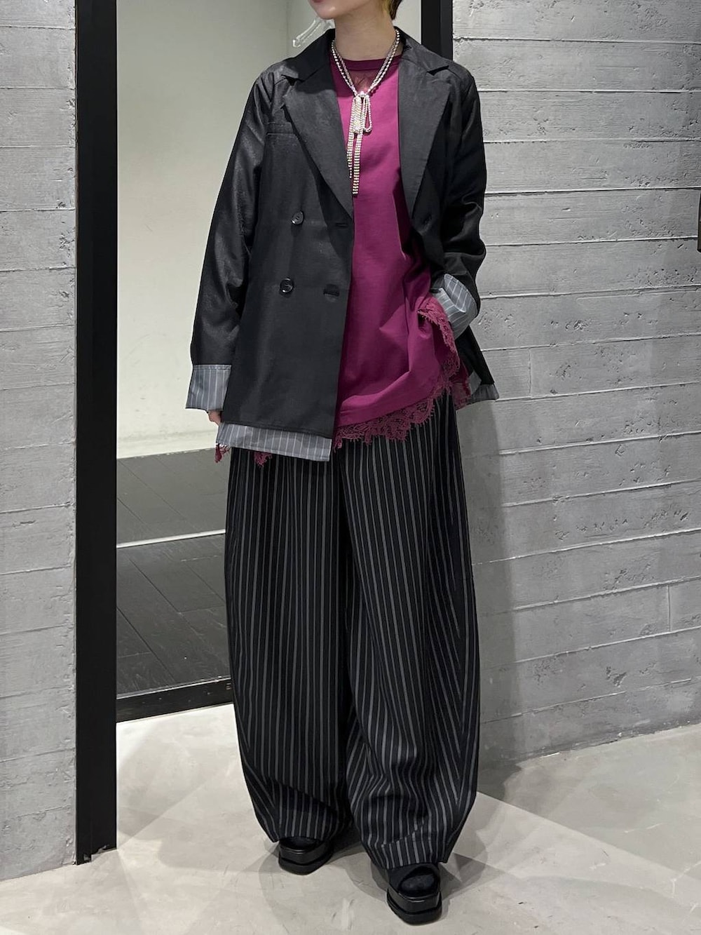 ブラック系のブーツ、ピンク系のTシャツ/カットソー、ブラック系のスラックスを着用したレディースの春コーディネートの5枚目の写真