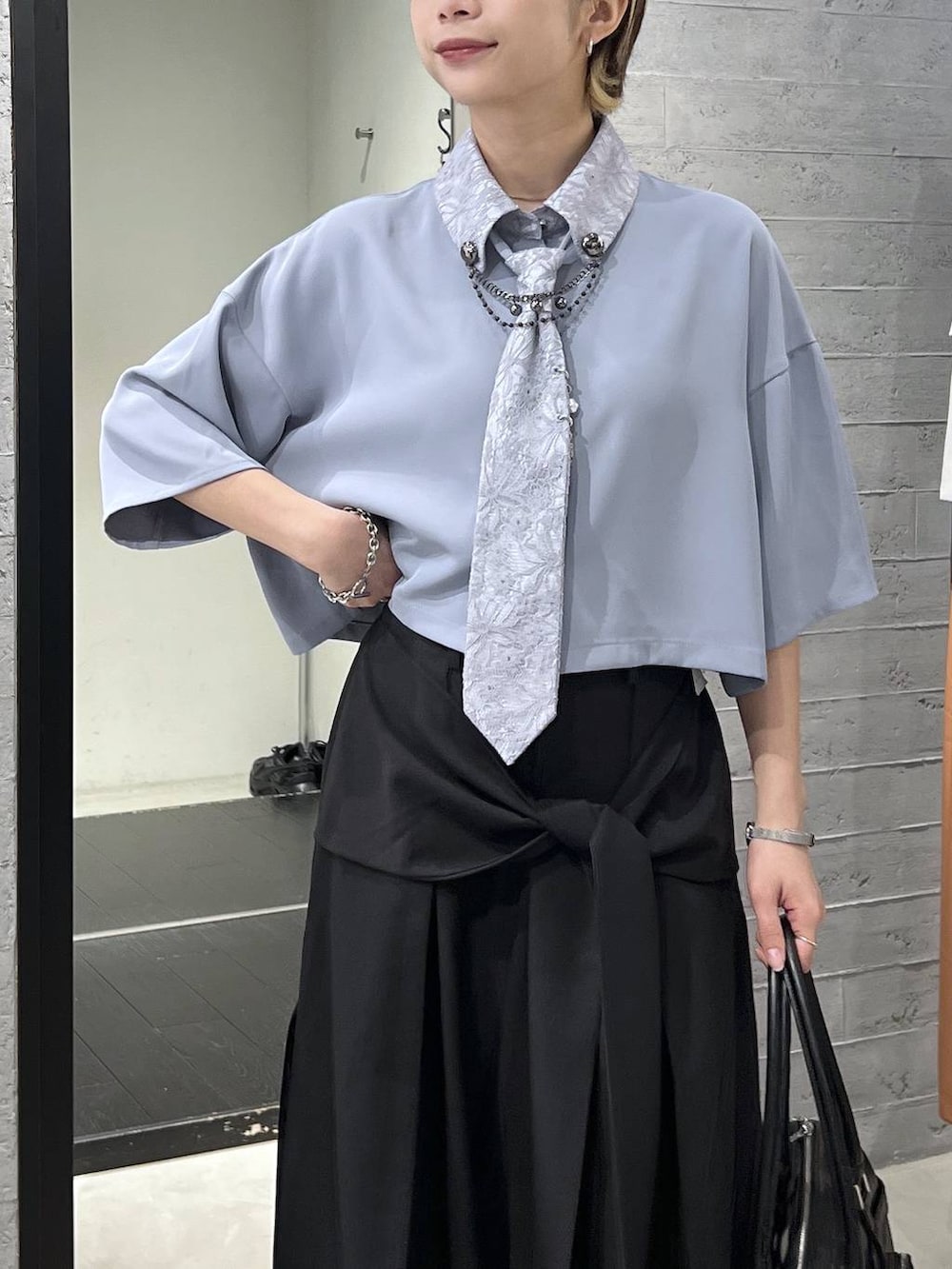 ブラック系のサンダル、ブラック系のボストンバッグ、ブルー系のシャツ/ブラウスを着用したレディースの春コーディネートの2枚目の写真