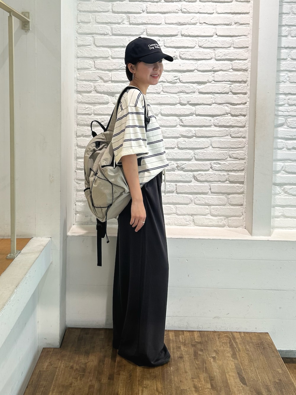ホワイト系のTシャツ/カットソー、グレー系のその他パンツ、グレー系のバックパック/リュックを着用したレディースの夏コーディネートの2枚目の写真