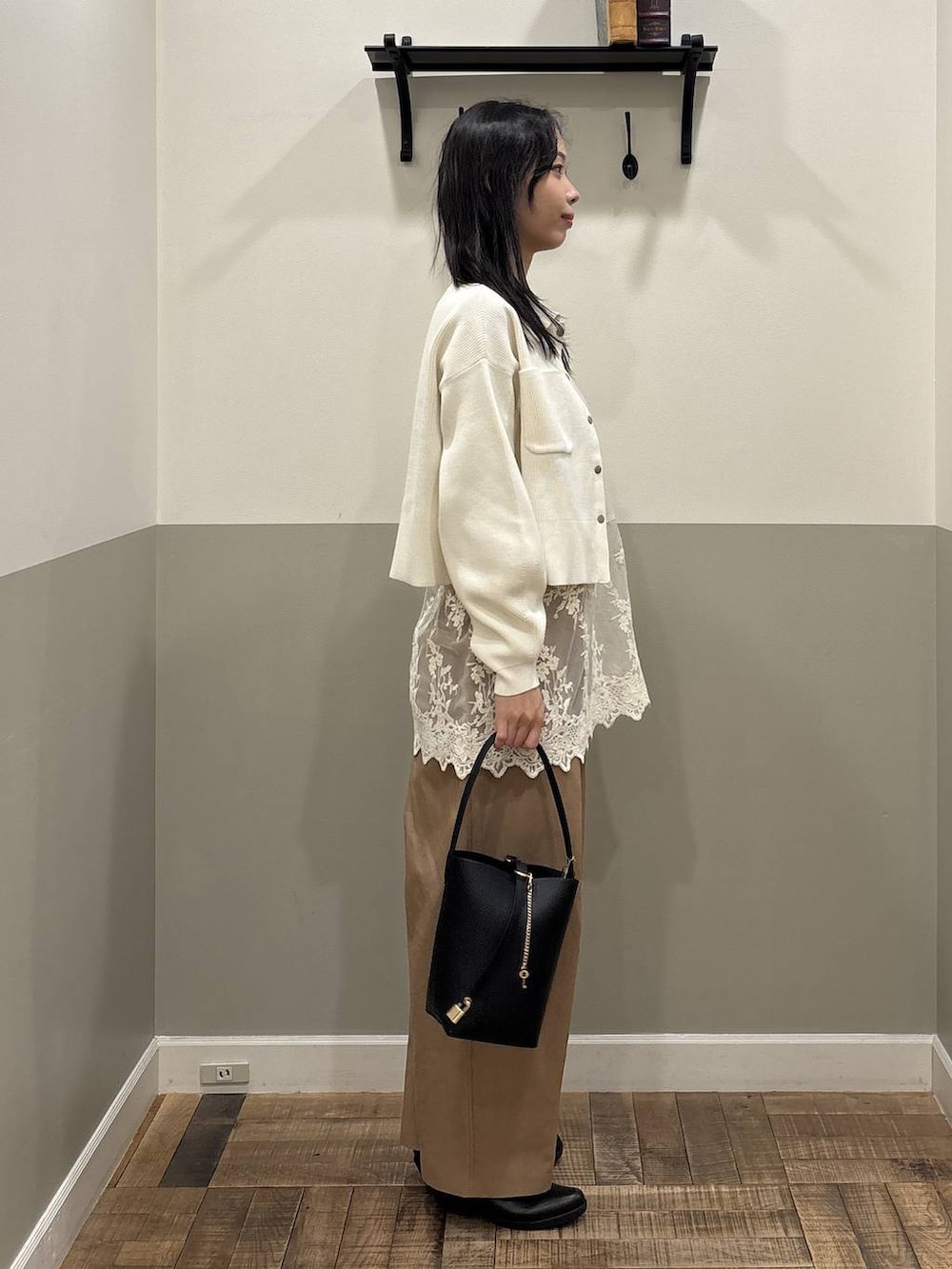 ホワイト系のチュニック、ブラック系のショルダーバッグ、ホワイト系のカーディガン/ボレロを着用したレディースの春コーディネートの2枚目の写真