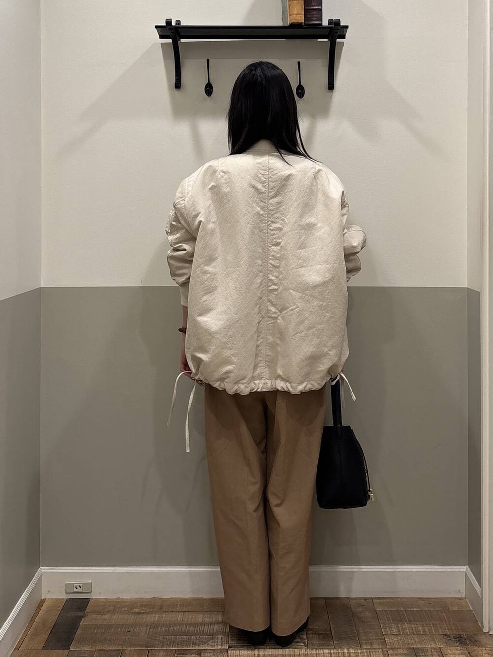 ベージュ系のMA-1、ブラック系のショルダーバッグ、ホワイト系のカーディガン/ボレロを着用したレディースの春コーディネートの3枚目の写真