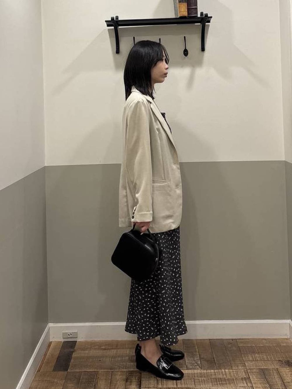 ブラック系のローファー、ベージュ系のノーカラージャケット、ブラック系のワンピースを着用したレディースの春コーディネートの2枚目の写真