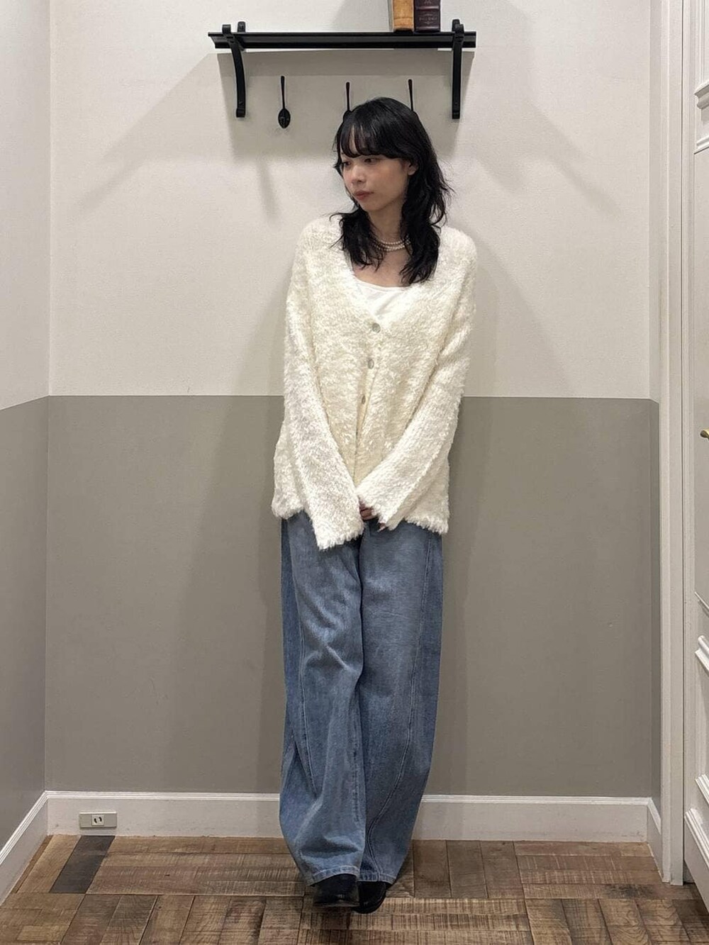 ブルー系のデニムパンツ、ブラック系のブーツ、ホワイト系のカーディガン/ボレロを着用したレディースの冬コーディネートの2枚目の写真