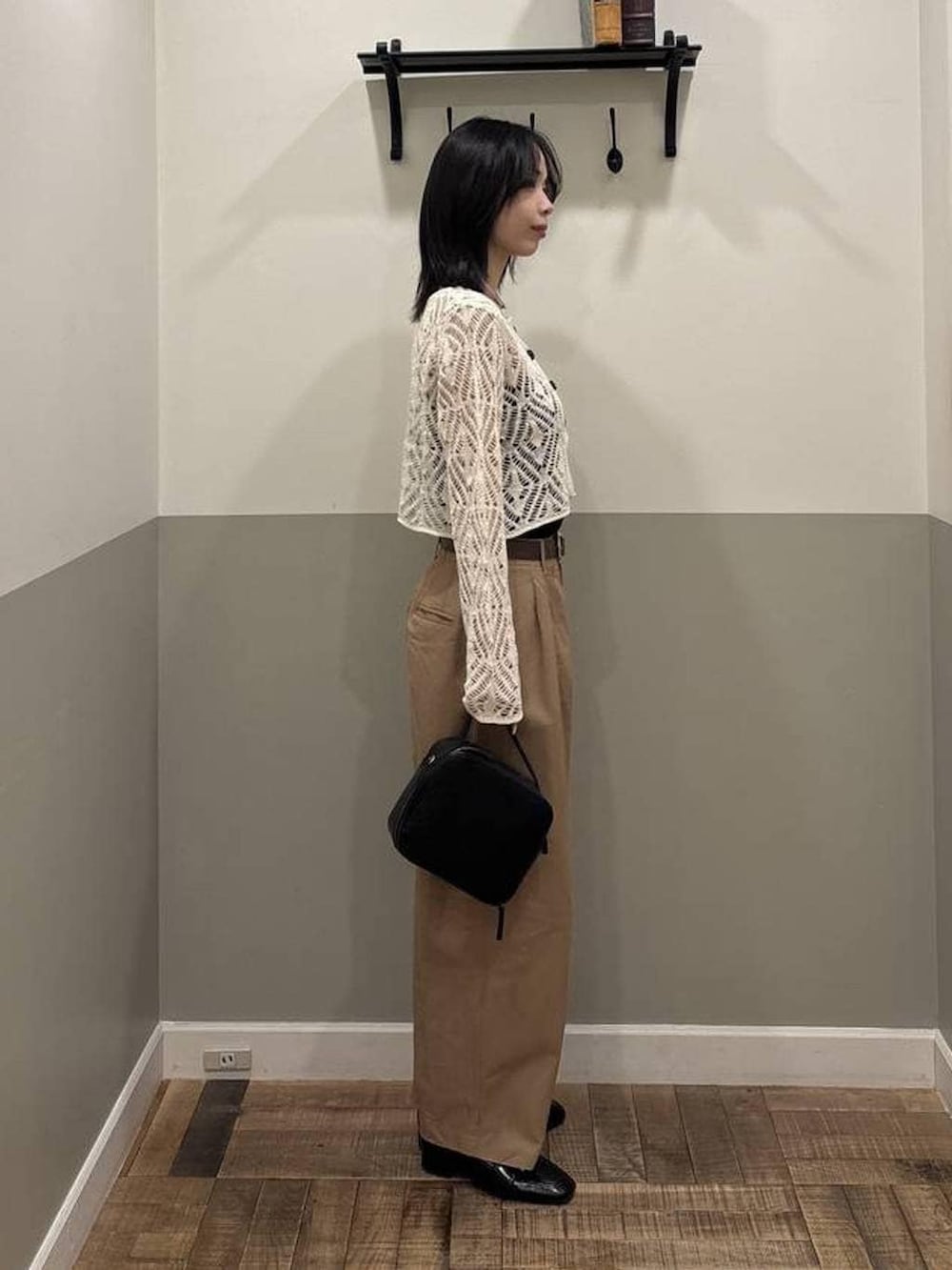 ブラック系のローファー、ホワイト系のカーディガン/ボレロ、ブラック系のショルダーバッグを着用したレディースの春コーディネートの2枚目の写真