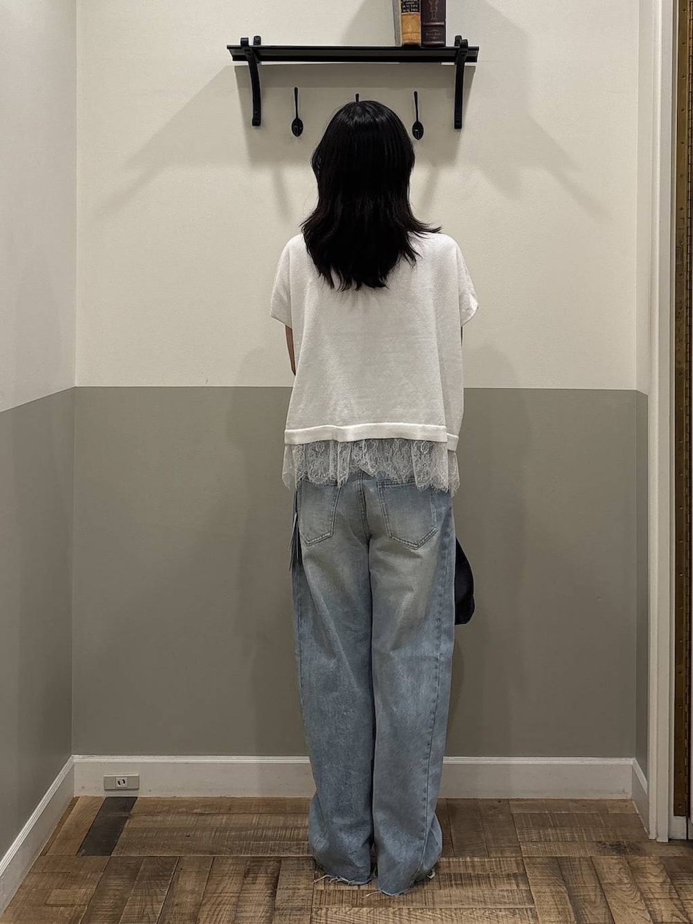 ブルー系のデニムパンツ、ブラック系のショルダーバッグ、ホワイト系のニット/セーターを着用したレディースの夏コーディネートの3枚目の写真