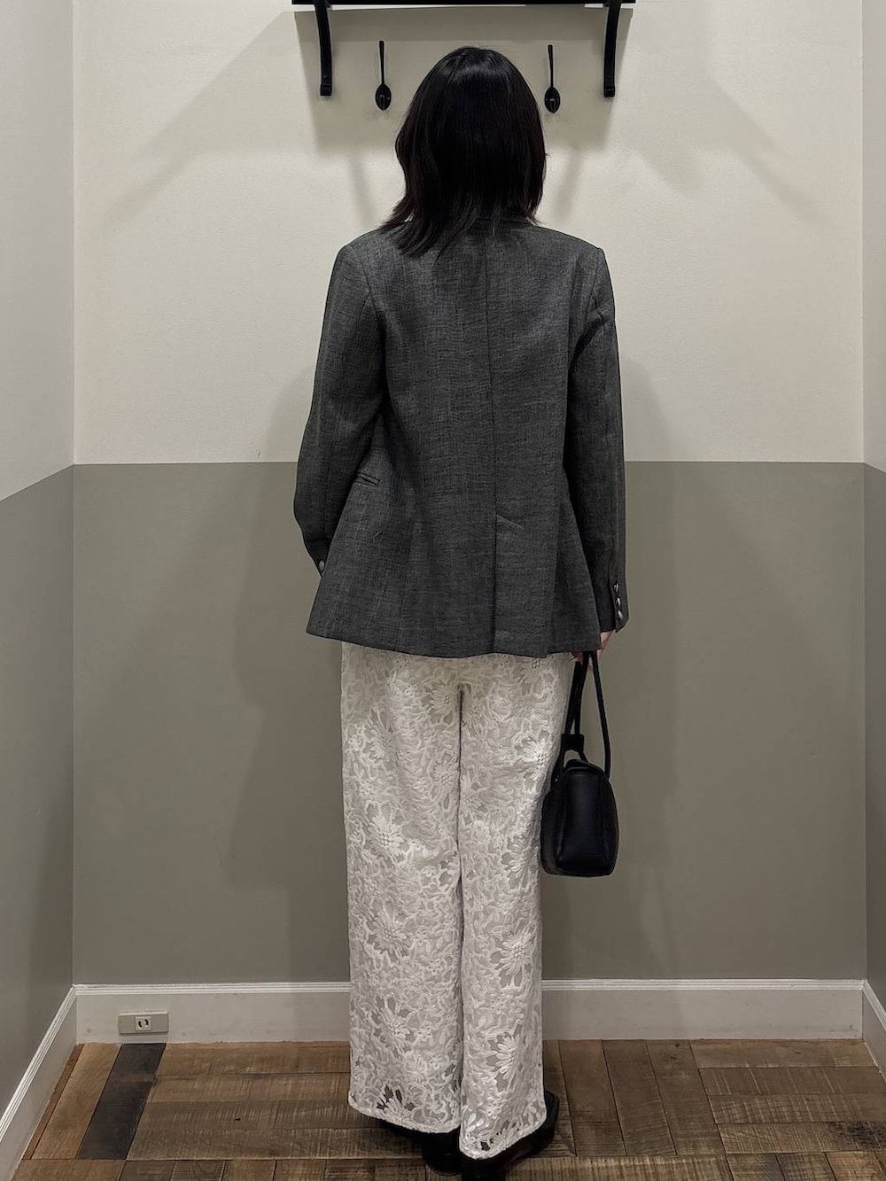 ブラック系のテーラードジャケット、ブラック系のローファー、ブラック系のショルダーバッグを着用したレディースの春コーディネートの3枚目の写真