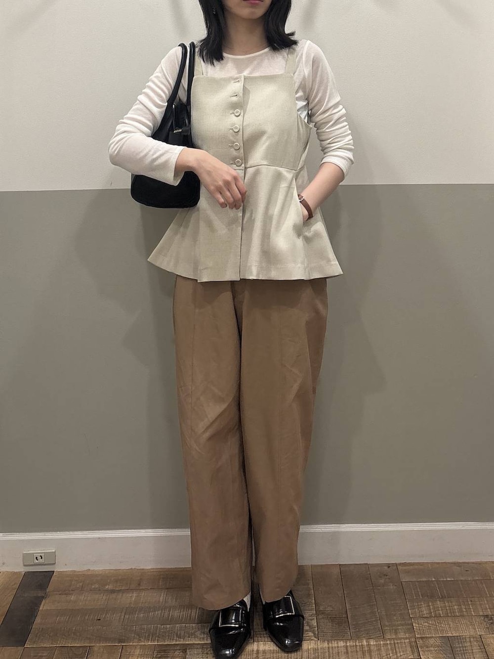 ブラック系のローファー、ベージュ系のベスト、ホワイト系のTシャツ/カットソーを着用したレディースの春コーディネートの2枚目の写真