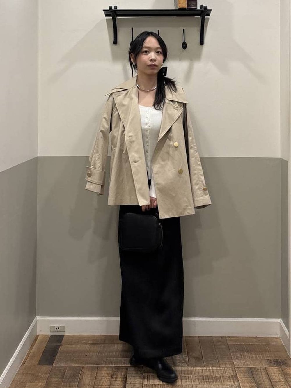 ベージュ系のトレンチコート、ホワイト系のカーディガン/ボレロ、ブラック系のショルダーバッグを着用したレディースの春コーディネートの4枚目の写真