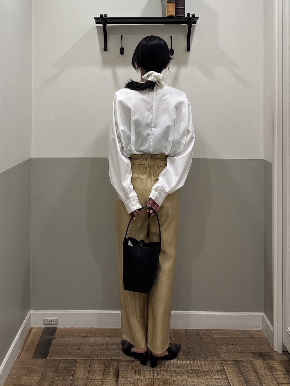 ブラック系のパンプス、ホワイト系のTシャツ/カットソー、ブラック系のショルダーバッグを着用したレディースの冬コーディネートの2枚目の写真