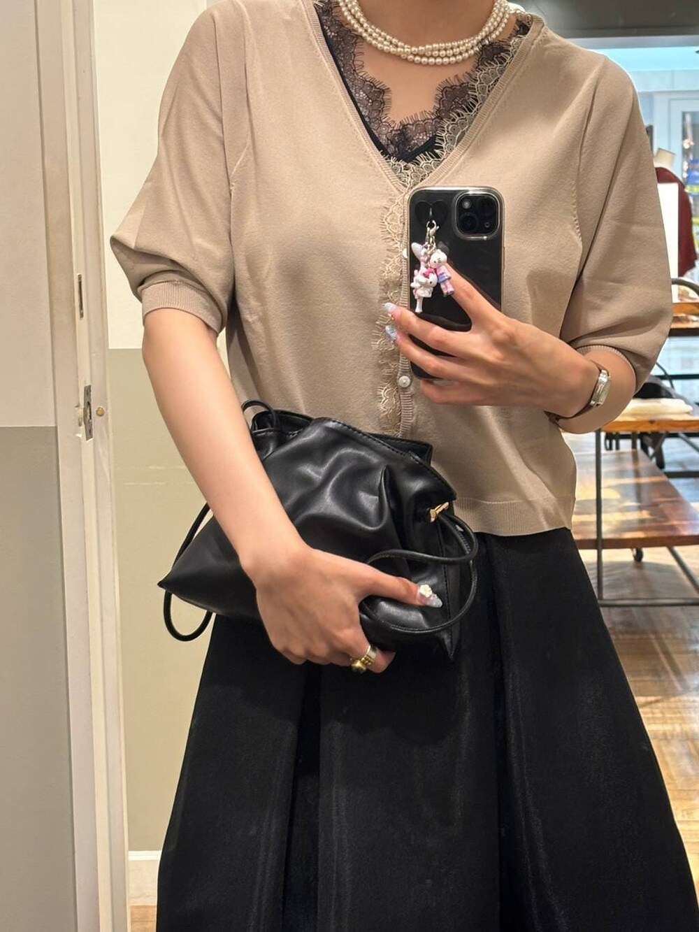 ブラック系のタンクトップ、ブラック系のスカート、ブラック系のショルダーバッグを着用したレディースの夏コーディネートの2枚目の写真