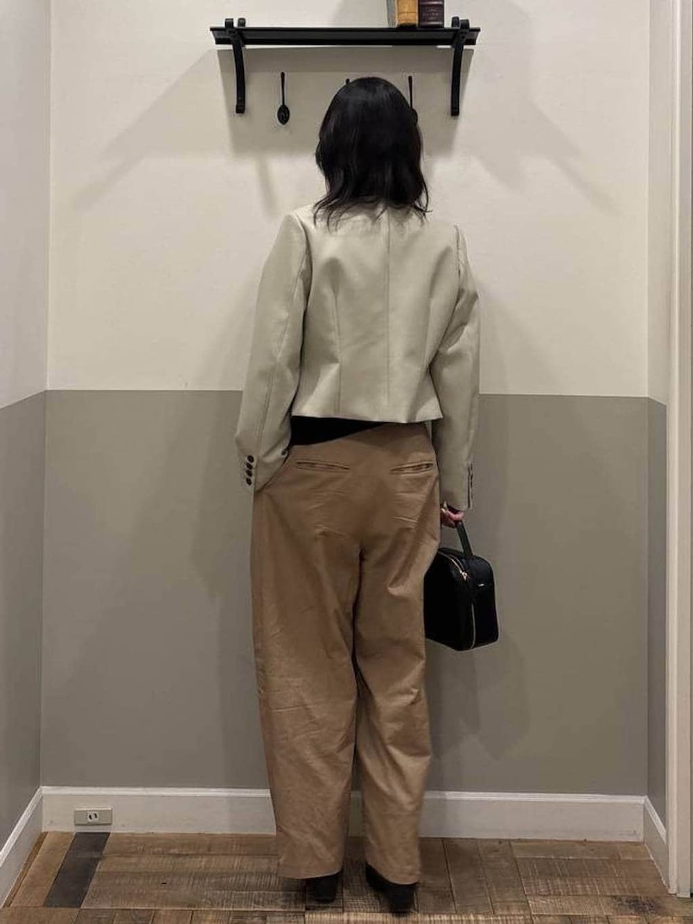 ブラウン系のチノパンツ、ブラック系のショルダーバッグ、ベージュ系のノーカラージャケットを着用したレディースの春コーディネートの3枚目の写真