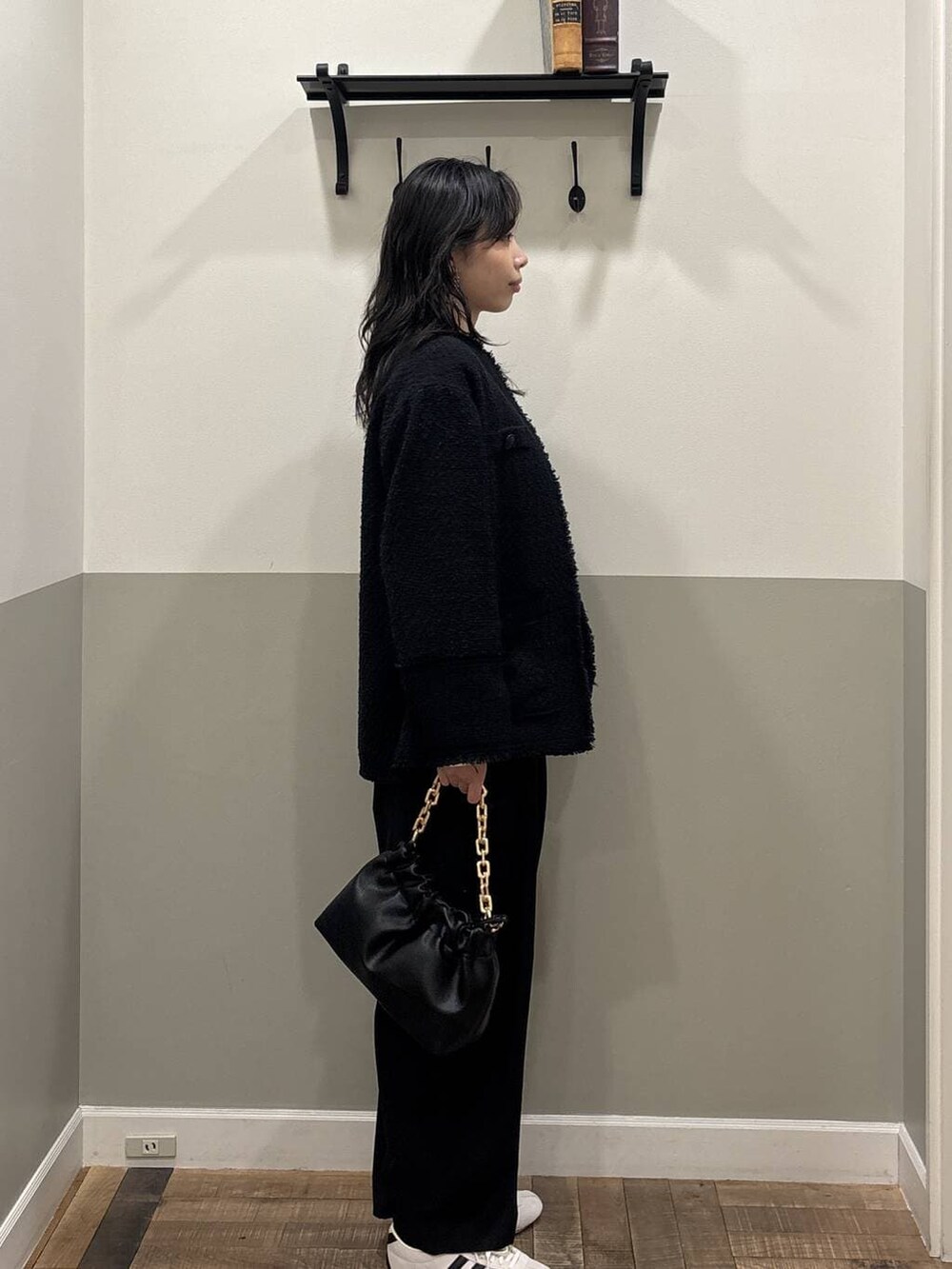 ブラック系のショルダーバッグ、ホワイト系のスニーカー、ブルー系のノーカラージャケットを着用したレディースの冬コーディネートの3枚目の写真