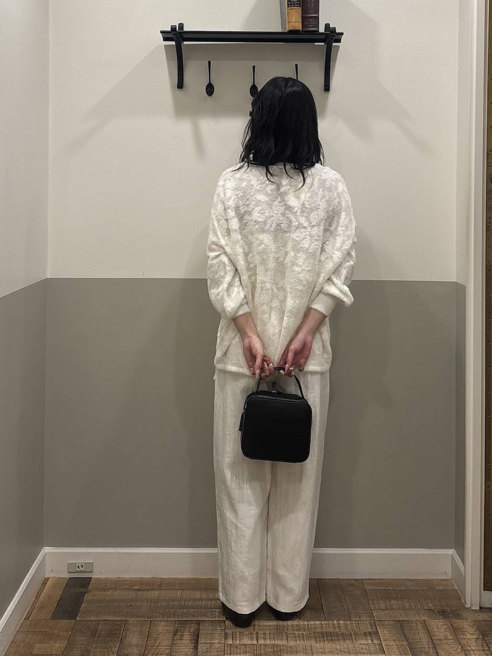 ホワイト系のニット/セーター、ブラック系のショルダーバッグ、ホワイト系のTシャツ/カットソーを着用したレディースの冬コーディネートの3枚目の写真