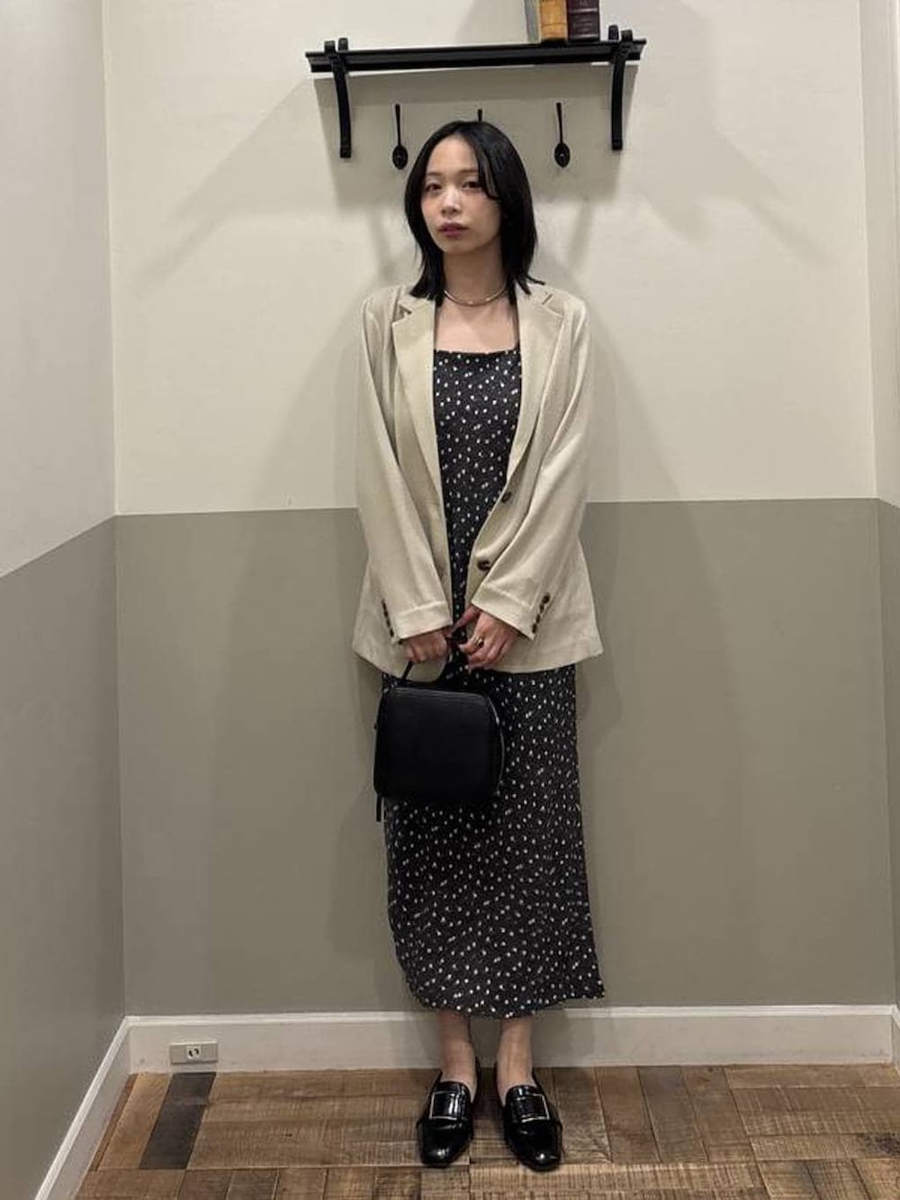 ブラック系のローファー、ベージュ系のノーカラージャケット、ブラック系のワンピースを着用したレディースの春コーディネートの4枚目の写真