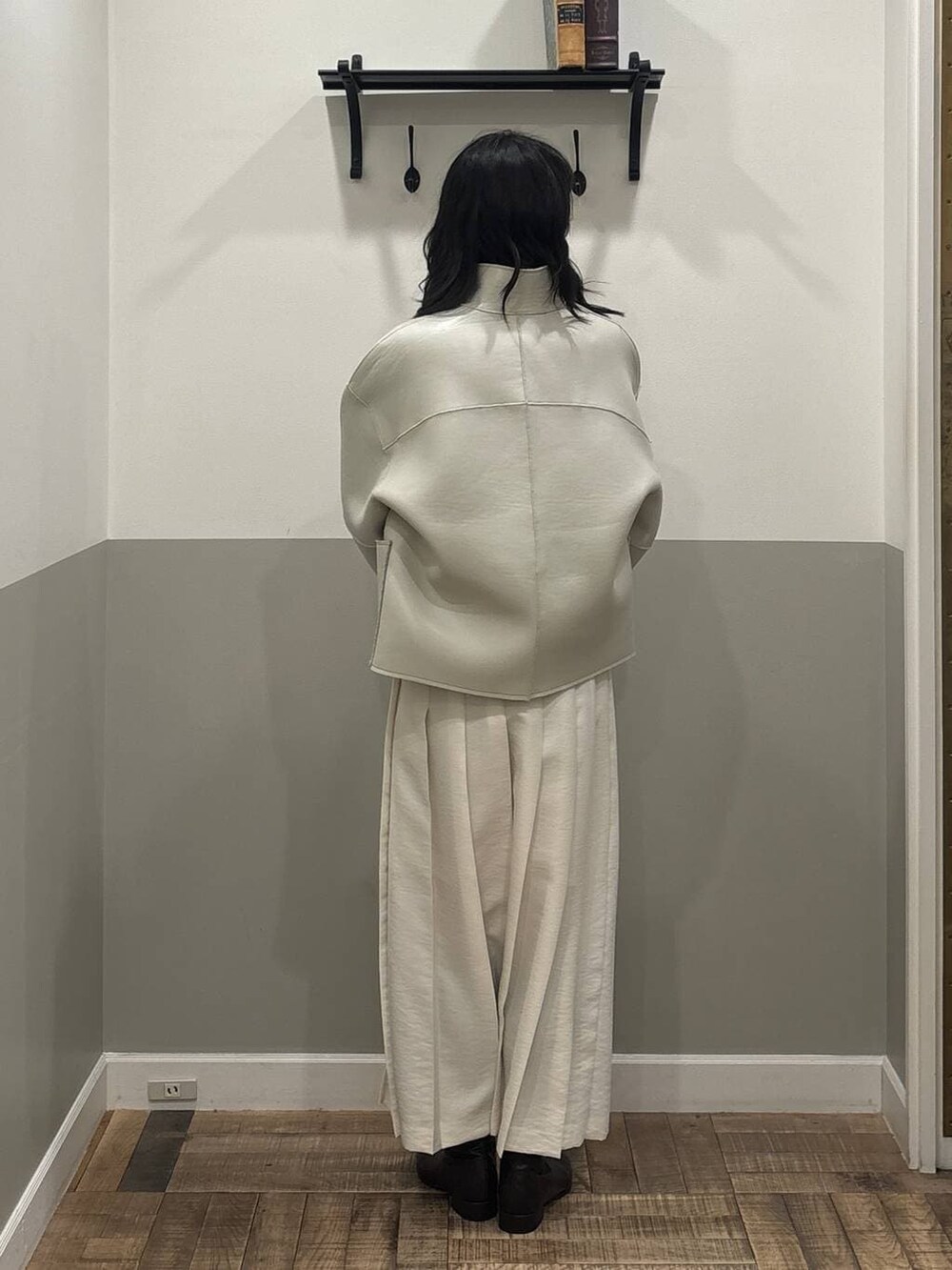 グリーン系のショルダーバッグ、ベージュ系のブルゾン、ホワイト系のスカートを着用したレディースの冬コーディネートの2枚目の写真