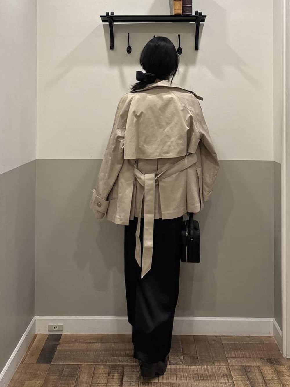 ベージュ系のトレンチコート、ホワイト系のカーディガン/ボレロ、ブラック系のショルダーバッグを着用したレディースの春コーディネートの3枚目の写真