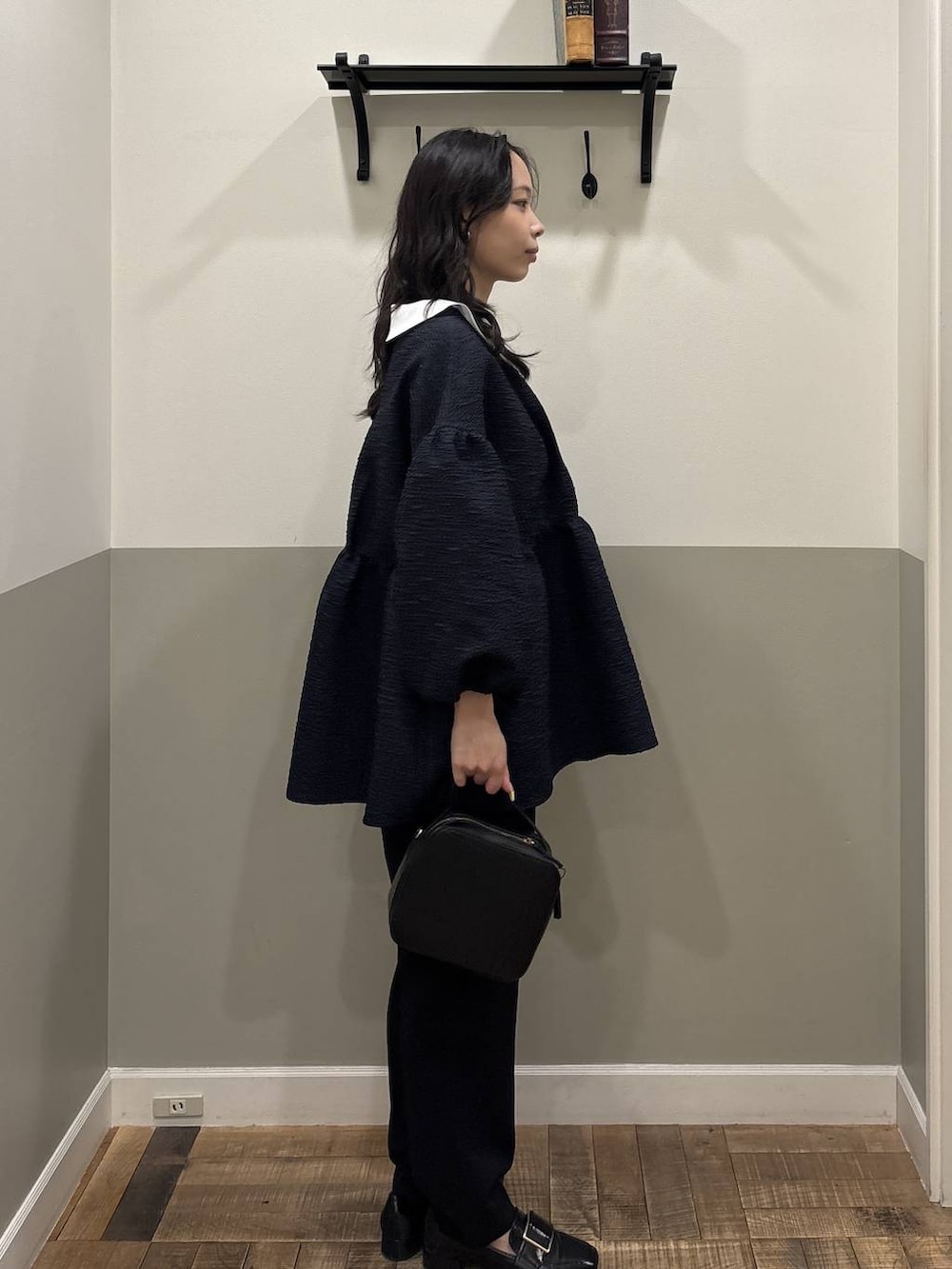 ブルー系のスーツセット、ブラック系のローファー、ブラック系のショルダーバッグを着用したレディースの冬コーディネートの2枚目の写真