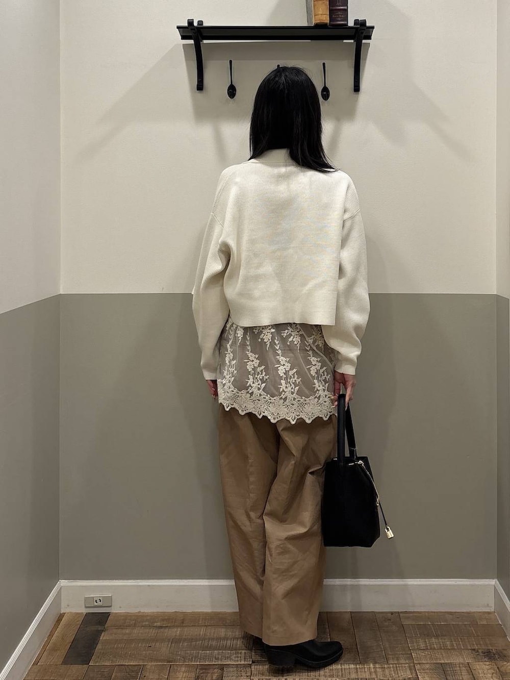 ホワイト系のチュニック、ブラック系のショルダーバッグ、ホワイト系のカーディガン/ボレロを着用したレディースの春コーディネートの3枚目の写真