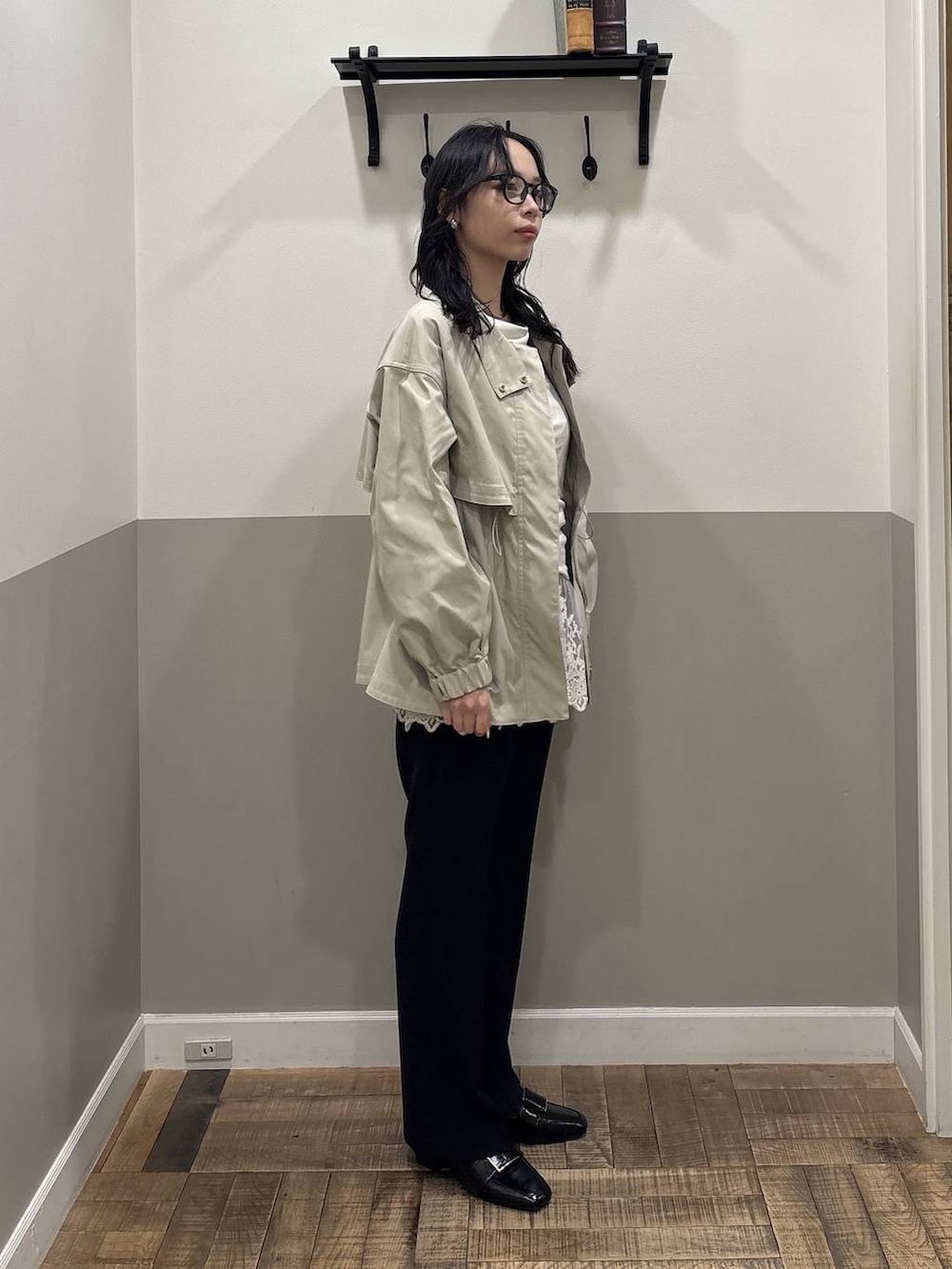 グリーン系のブルゾン、ホワイト系のチュニック、ブラック系のローファーを着用したレディースの春コーディネートの2枚目の写真