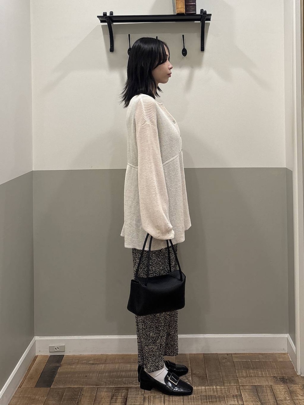 ベージュ系のスカート、ブラック系のローファー、ブラック系のショルダーバッグを着用したレディースの春コーディネートの2枚目の写真