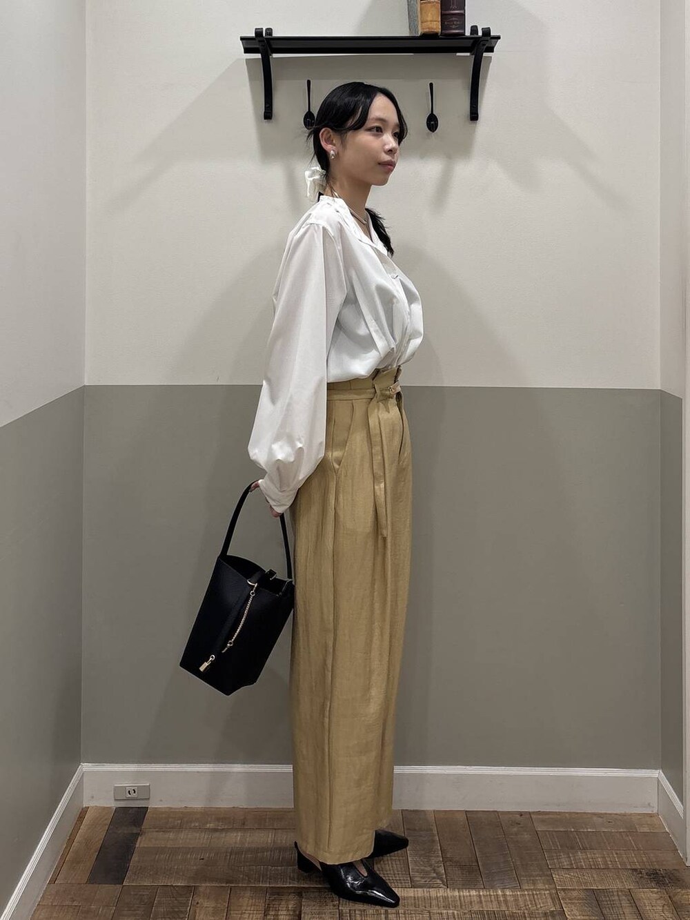 ブラック系のパンプス、ホワイト系のTシャツ/カットソー、ブラック系のショルダーバッグを着用したレディースの冬コーディネートの3枚目の写真