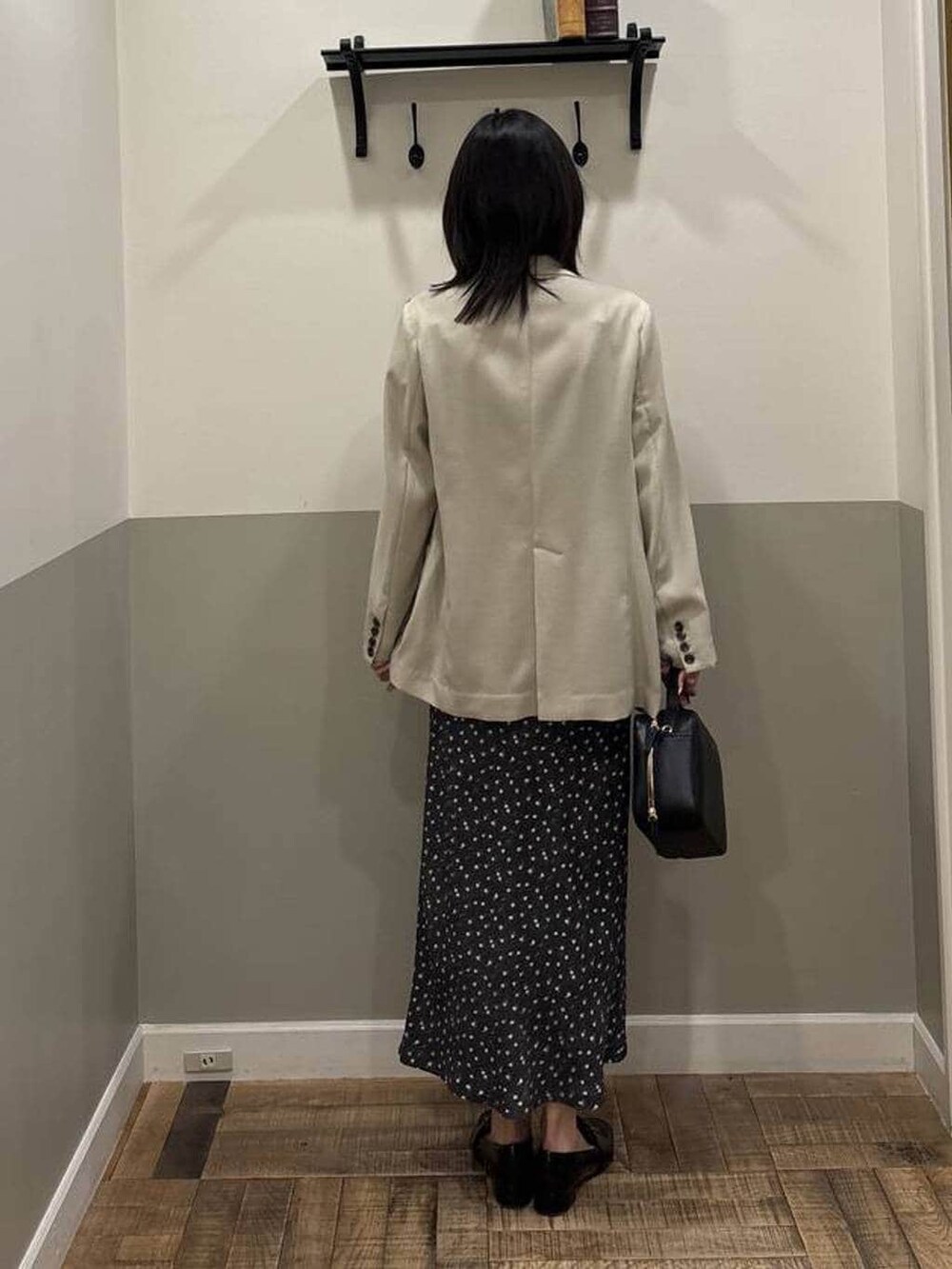 ブラック系のローファー、ベージュ系のノーカラージャケット、ブラック系のワンピースを着用したレディースの春コーディネートの3枚目の写真