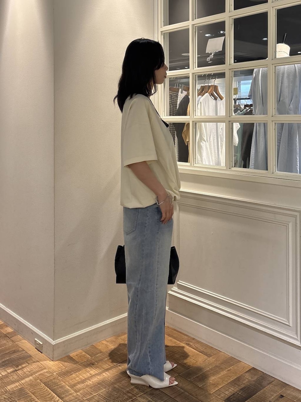 ホワイト系のTシャツ/カットソー、ブルー系のデニムパンツ、ブラック系のショルダーバッグを着用したレディースの夏コーディネートの3枚目の写真