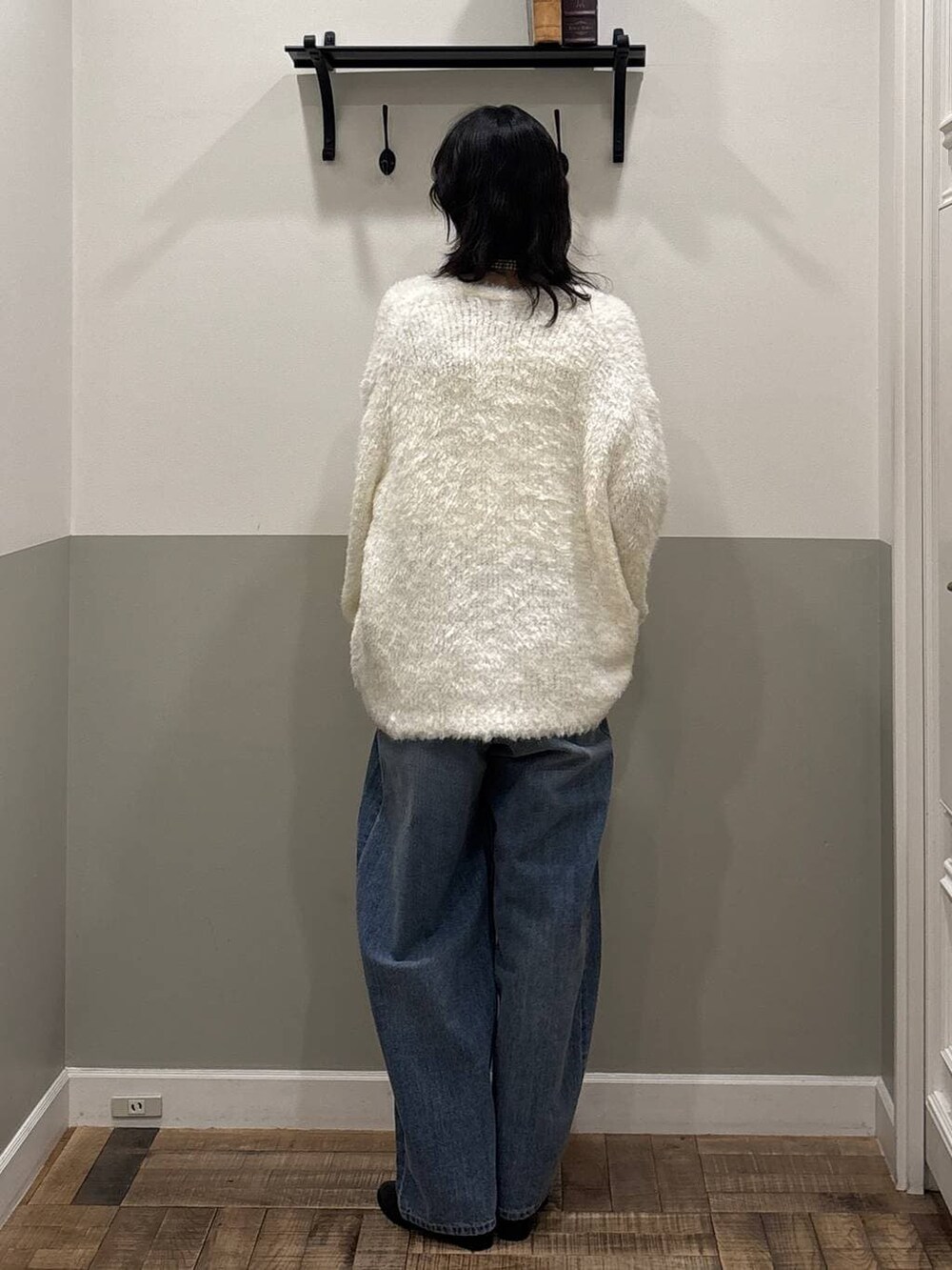 ブルー系のデニムパンツ、ブラック系のブーツ、ホワイト系のカーディガン/ボレロを着用したレディースの冬コーディネートの3枚目の写真