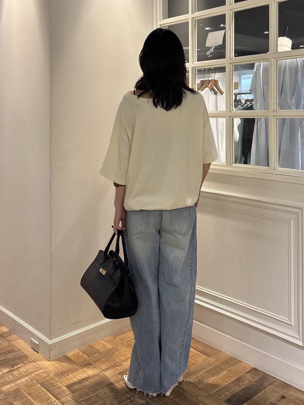 ホワイト系のTシャツ/カットソー、ブルー系のデニムパンツ、ブラック系のショルダーバッグを着用したレディースの夏コーディネートの2枚目の写真