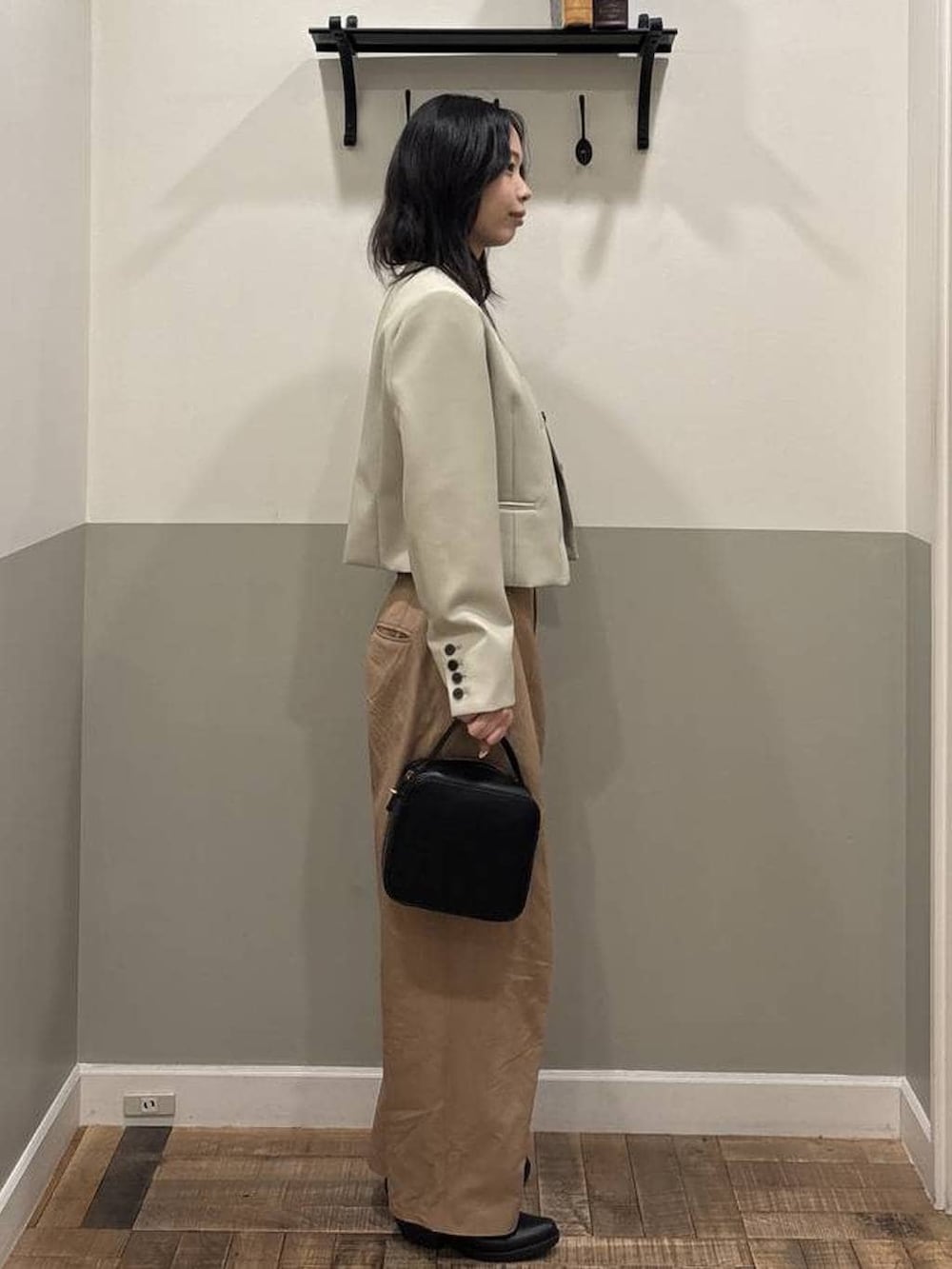 ブラウン系のチノパンツ、ブラック系のショルダーバッグ、ベージュ系のノーカラージャケットを着用したレディースの春コーディネートの2枚目の写真