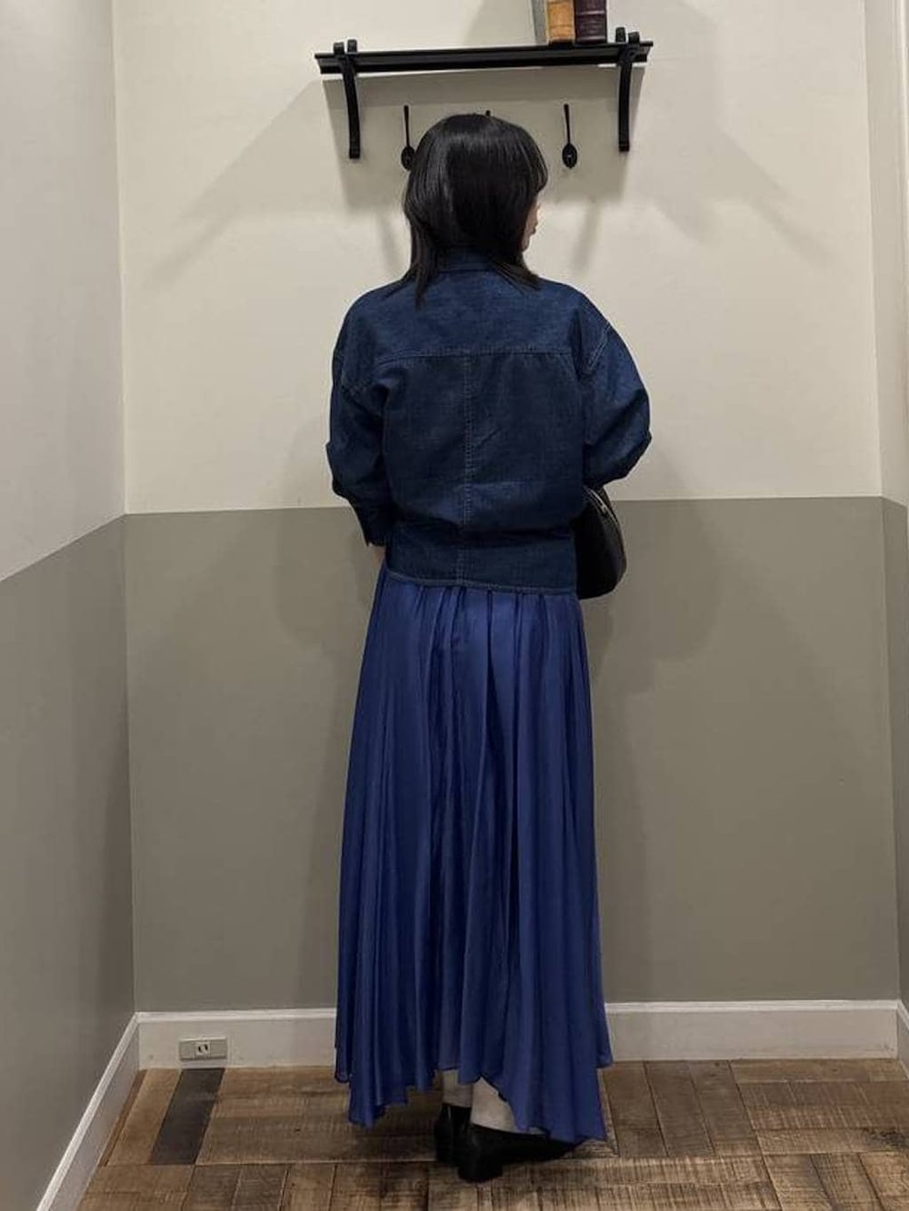 ブルー系のスカート、ブラック系のローファー、ブラック系のショルダーバッグを着用したレディースの春コーディネートの3枚目の写真