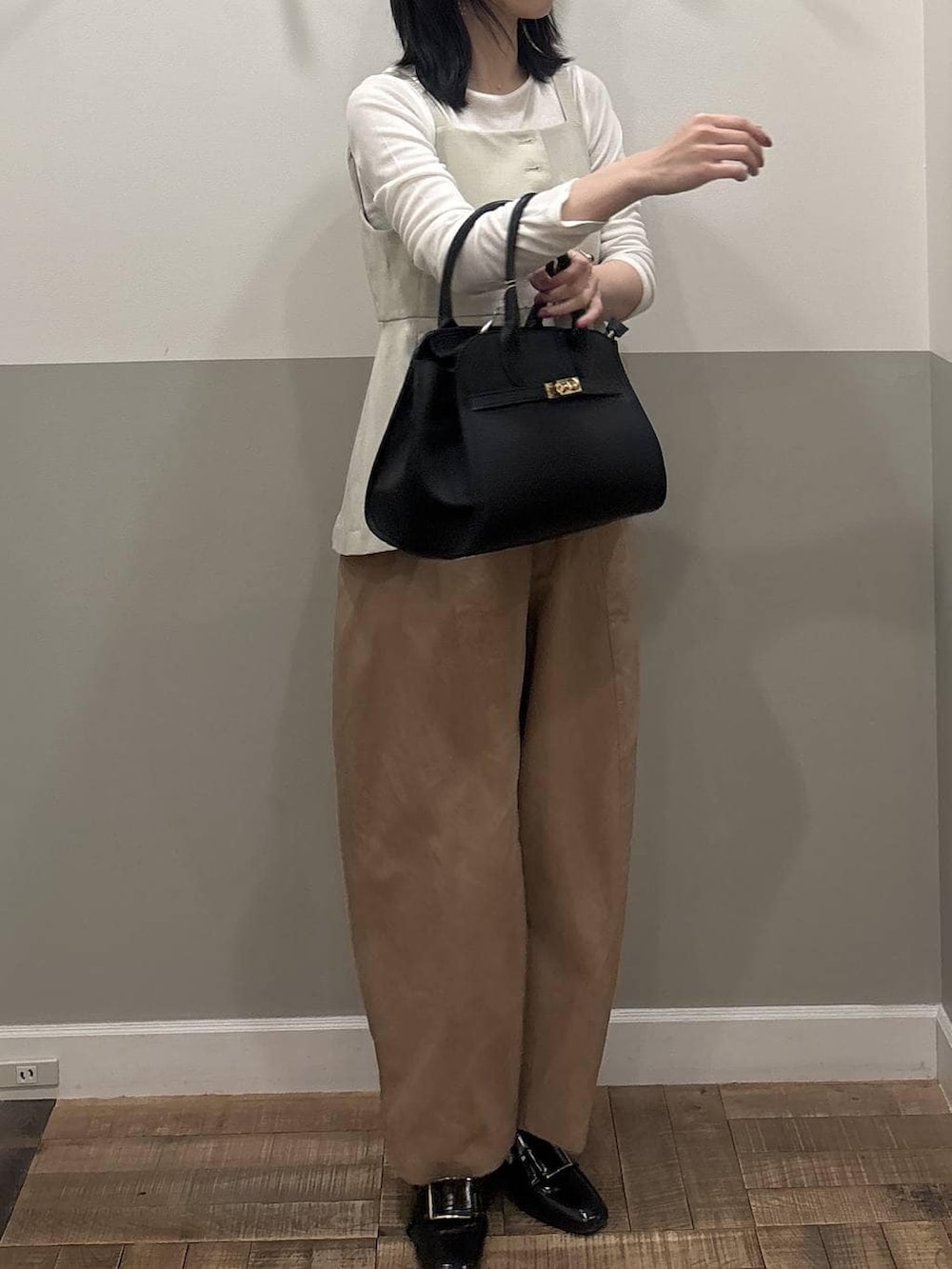 ブラック系のローファー、ベージュ系のベスト、ホワイト系のTシャツ/カットソーを着用したレディースの春コーディネートの3枚目の写真