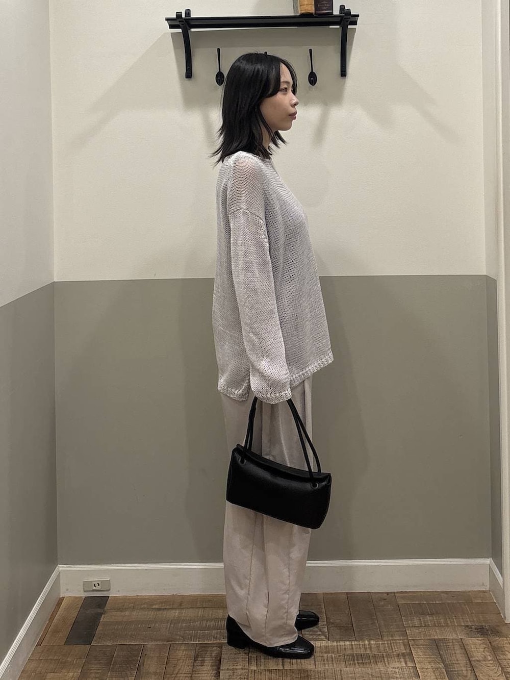 ブラック系のローファー、ブラック系のショルダーバッグ、グレー系のニット/セーターを着用したレディースの春コーディネートの2枚目の写真