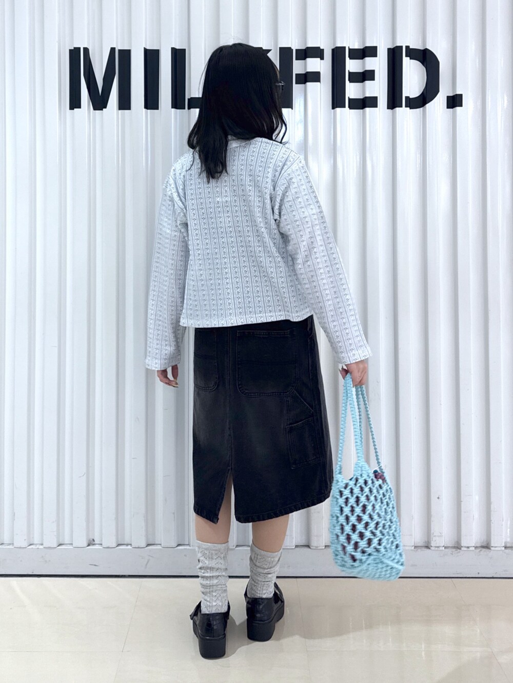 ブラック系のサロペット/オーバーオール、ホワイト系のTシャツ/カットソー、ホワイト系のカーディガン/ボレロを着用したレディースの春コーディネートの2枚目の写真