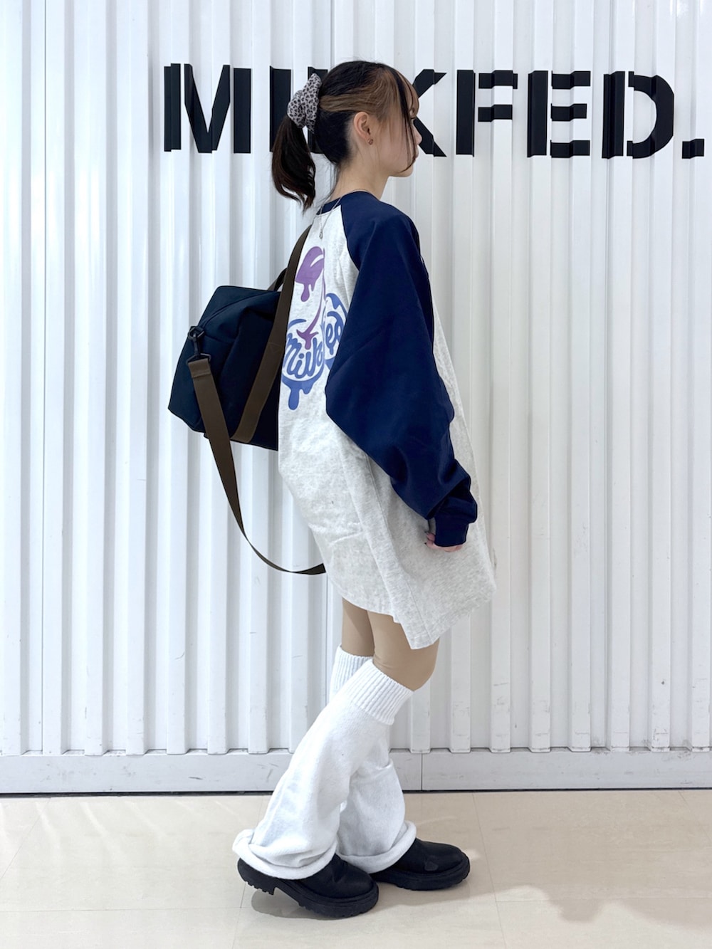 ブルー系のショルダーバッグ、ベージュ系のTシャツ/カットソー、レッド系のキーホルダーを着用したレディースの冬コーディネートの4枚目の写真