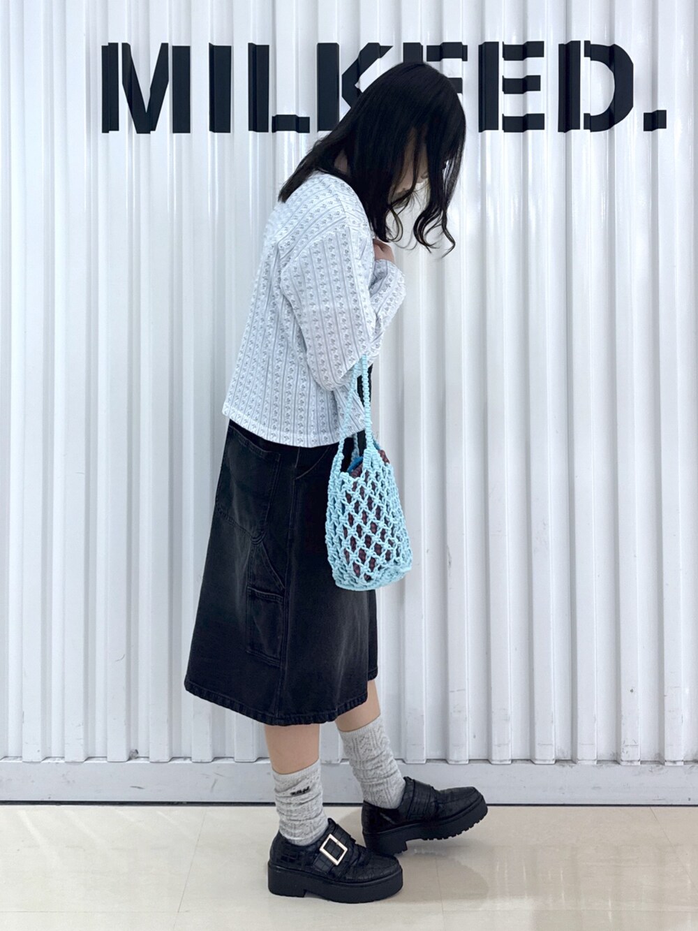 ブラック系のサロペット/オーバーオール、ホワイト系のTシャツ/カットソー、ホワイト系のカーディガン/ボレロを着用したレディースの春コーディネートの4枚目の写真