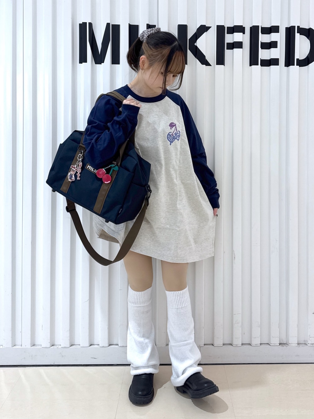 ブルー系のショルダーバッグ、ベージュ系のTシャツ/カットソー、レッド系のキーホルダーを着用したレディースの冬コーディネートの2枚目の写真