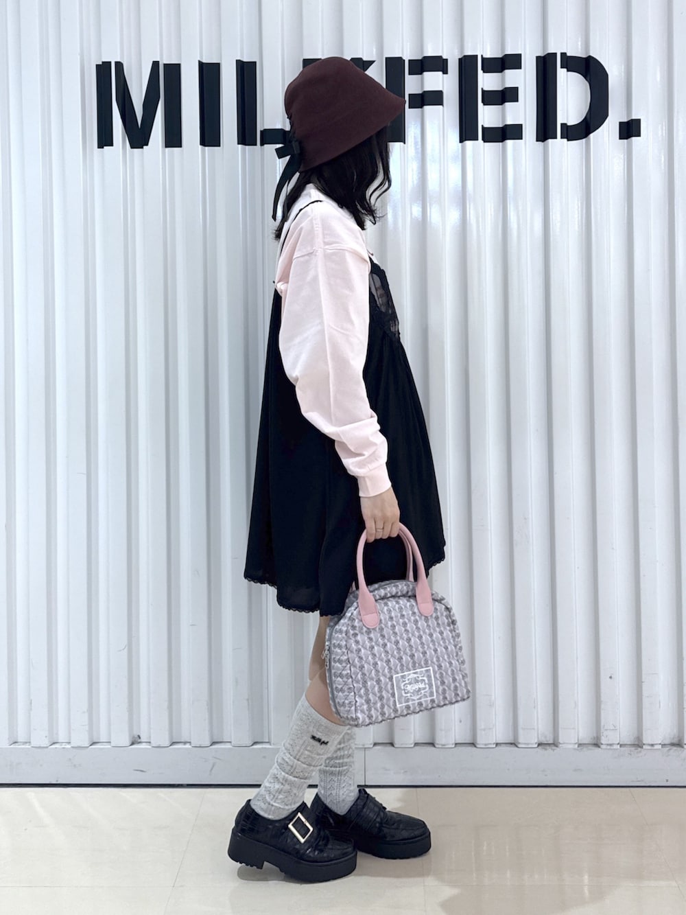 ブラック系のキャミソール、ピンク系のTシャツ/カットソー、ブラック系のスカートを着用したレディースの春コーディネートの2枚目の写真