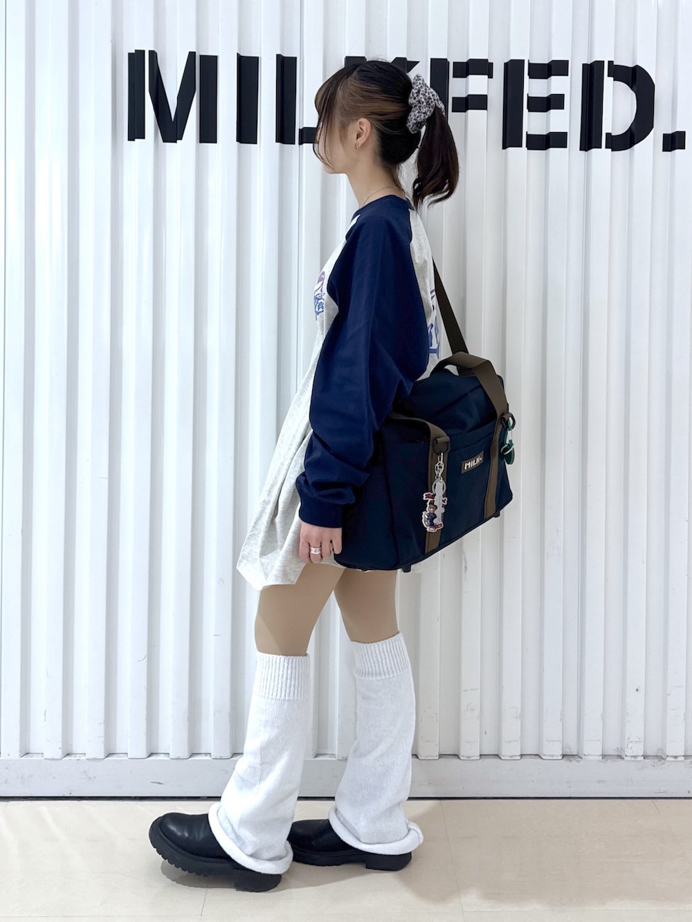 ブルー系のショルダーバッグ、ベージュ系のTシャツ/カットソー、レッド系のキーホルダーを着用したレディースの冬コーディネートの3枚目の写真