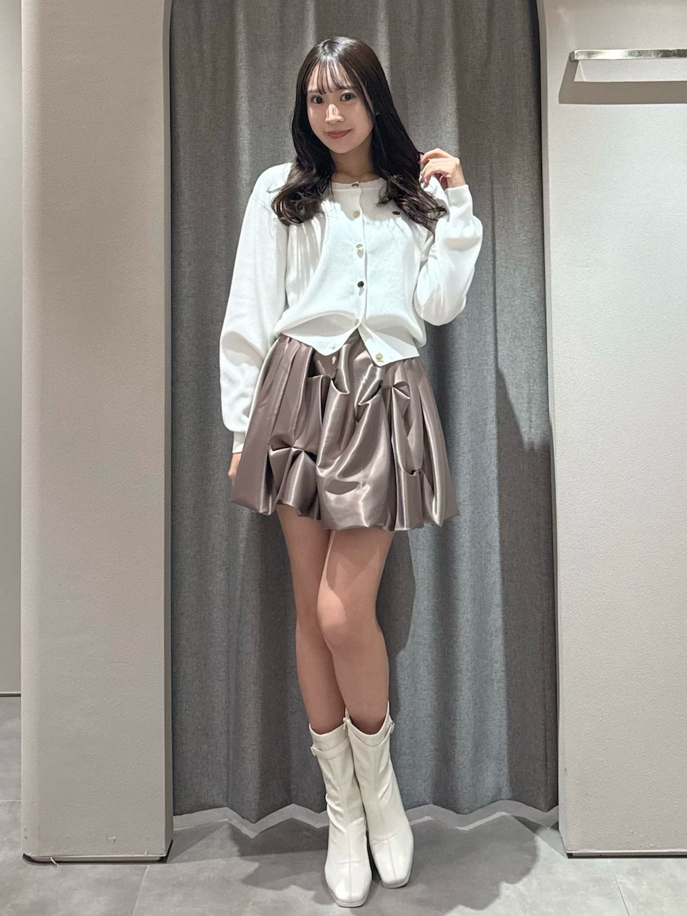 ホワイト系のカーディガン/ボレロ、ブラウン系のスカート、ホワイト系のブーツを着用したレディースの春コーディネートの4枚目の写真